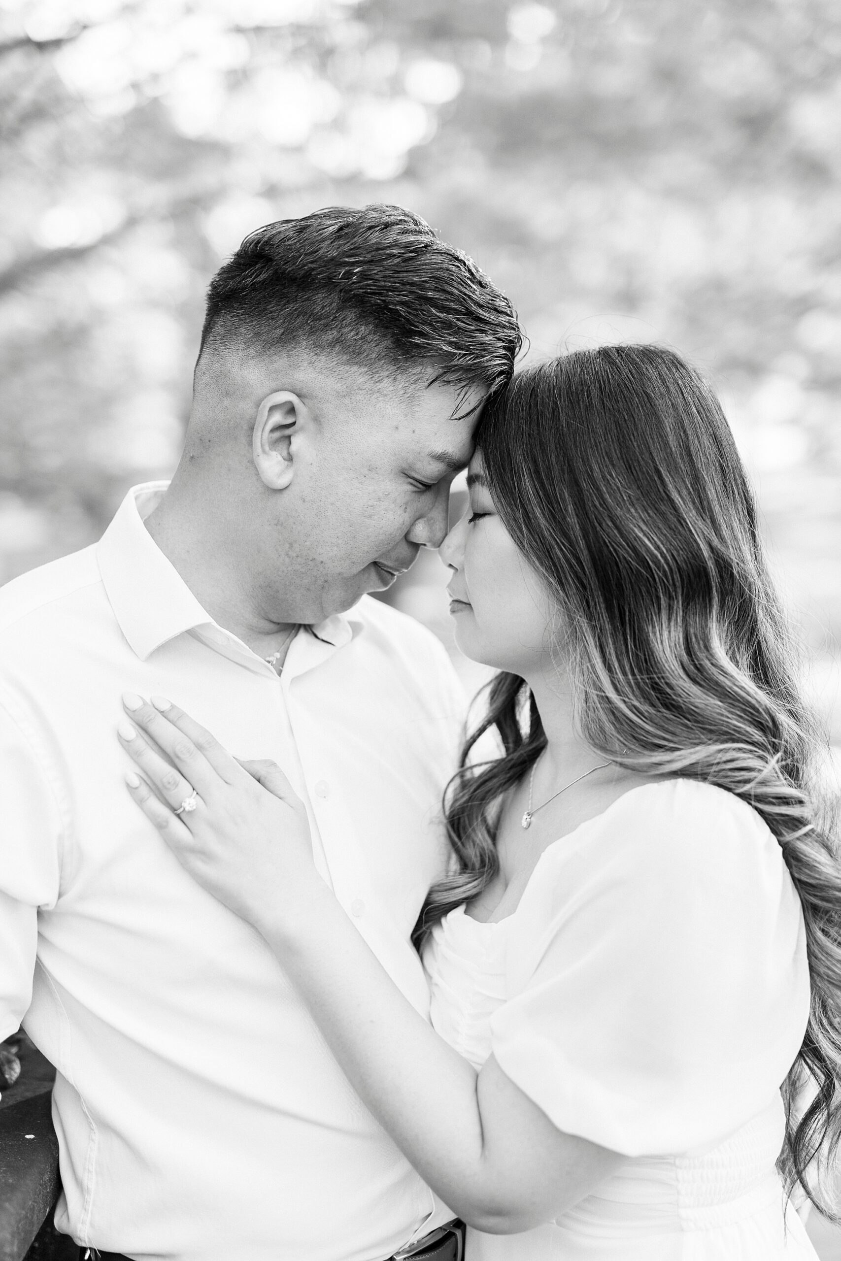 couple hugs leaning together on bridge inside Glencairn Garden