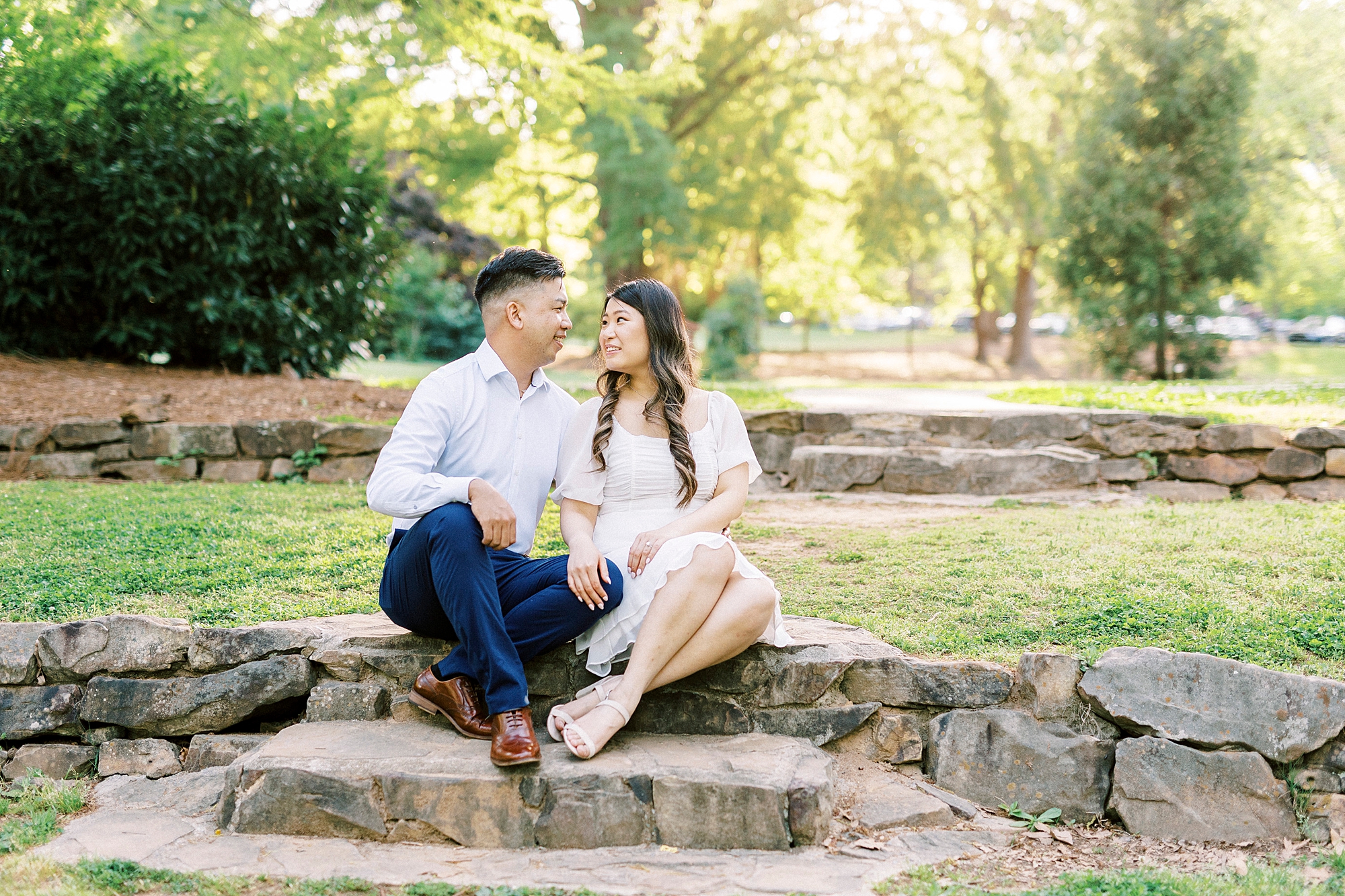 man and woman sit on stone staircase inside Glencairn Garden