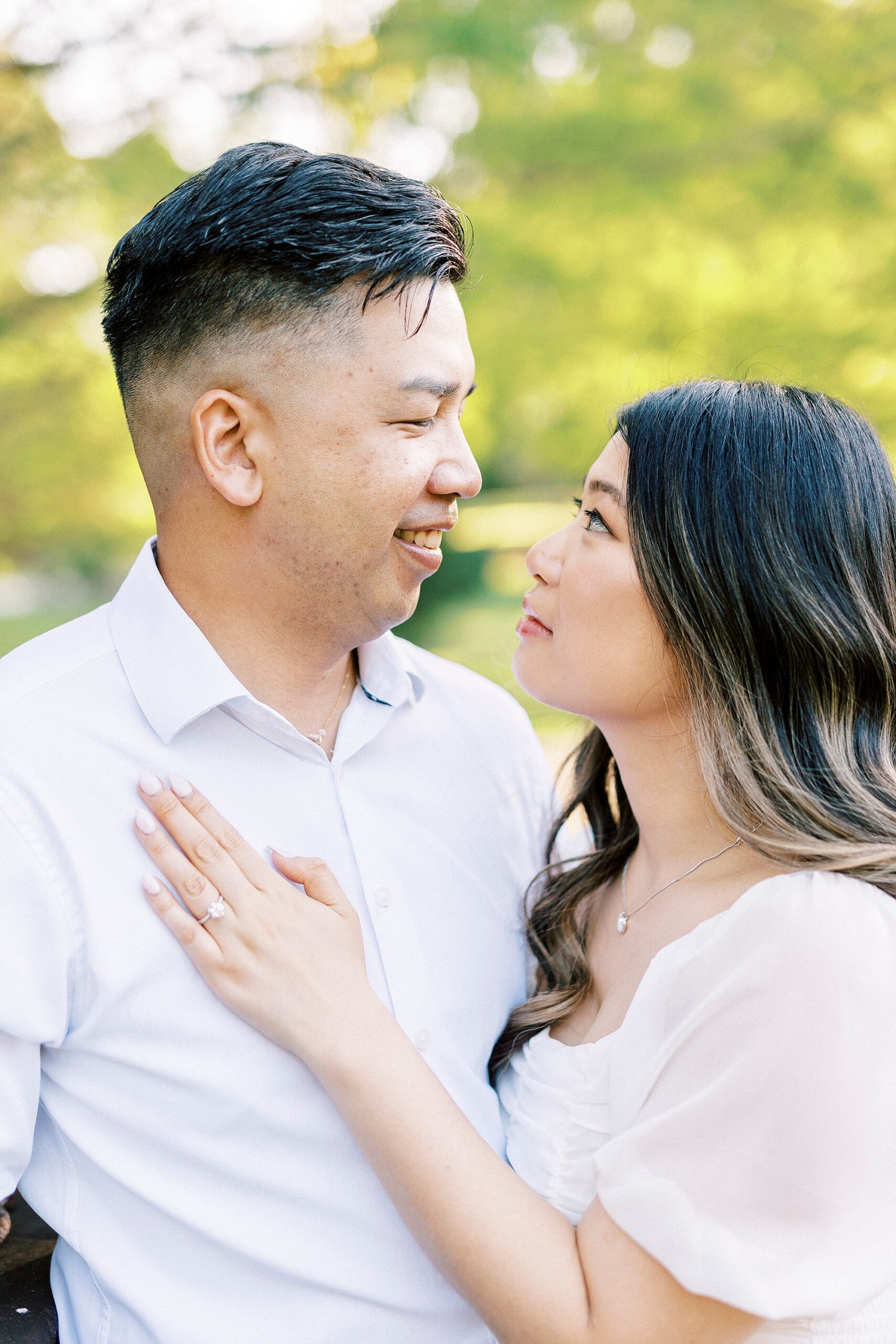 man looks at woman while she places her hand on his chest 