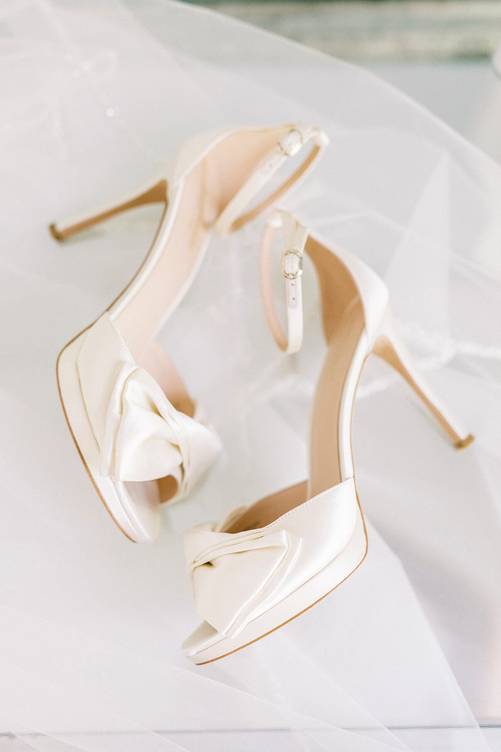 ivory heels lay on veil for bride