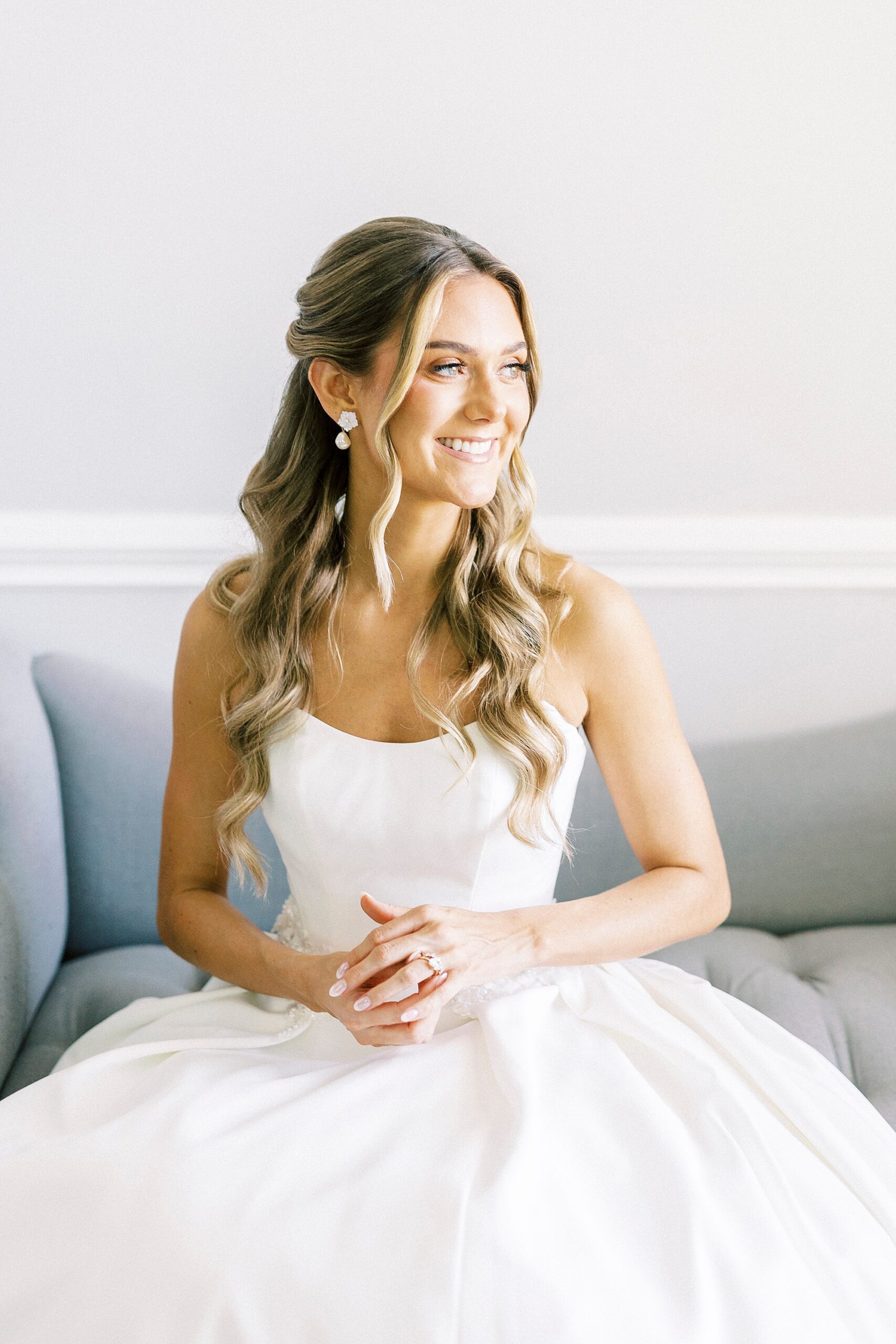 bride sits on blue couch holding hands in lap at Separk Mansion
