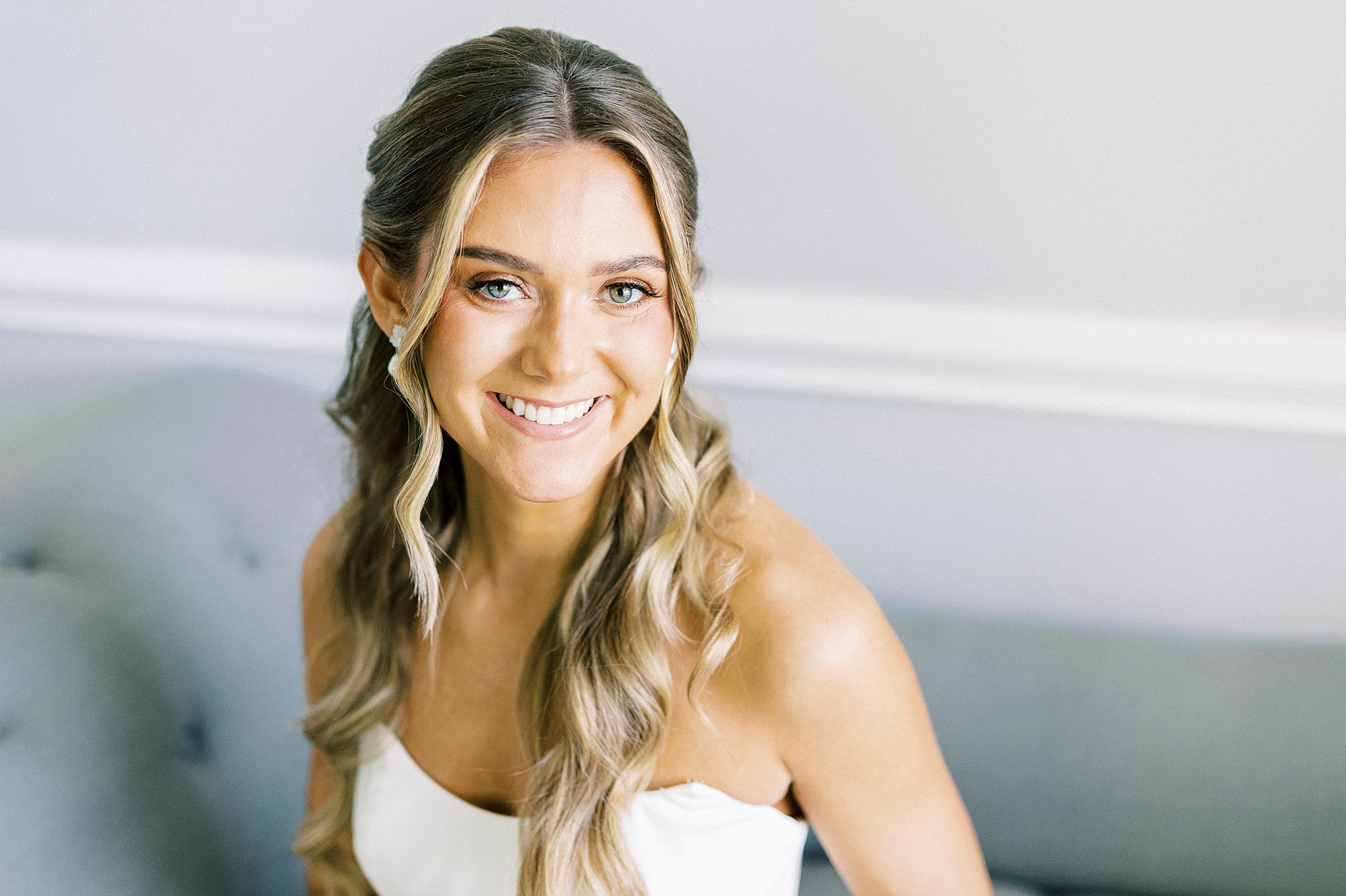 bride leans forward with curled hair over her shoulders 