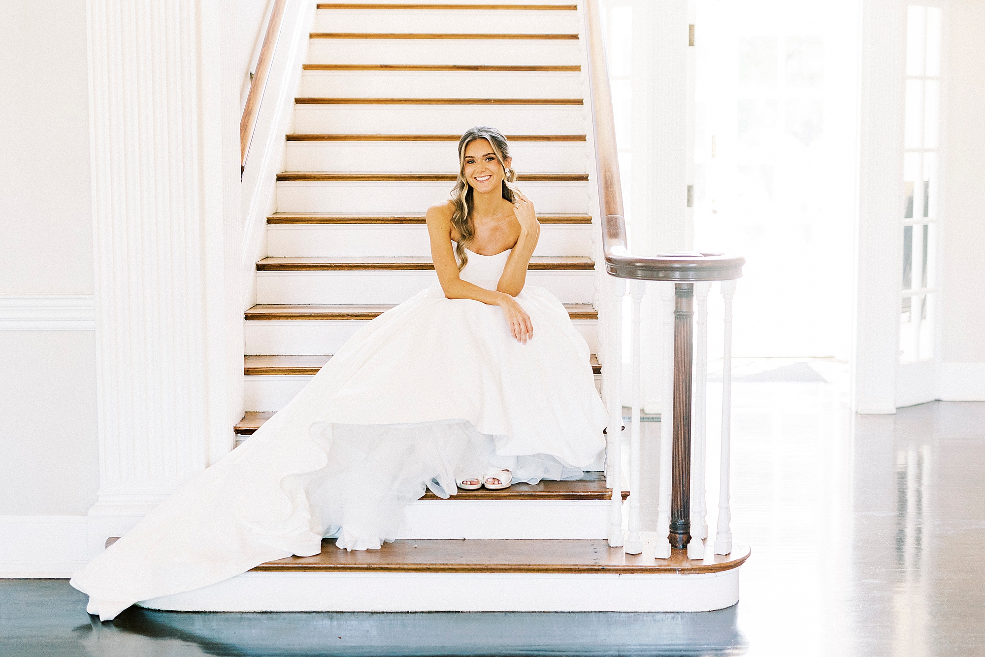 bride sits on steps leaning on fist during Separk Mansion bridal portraits 