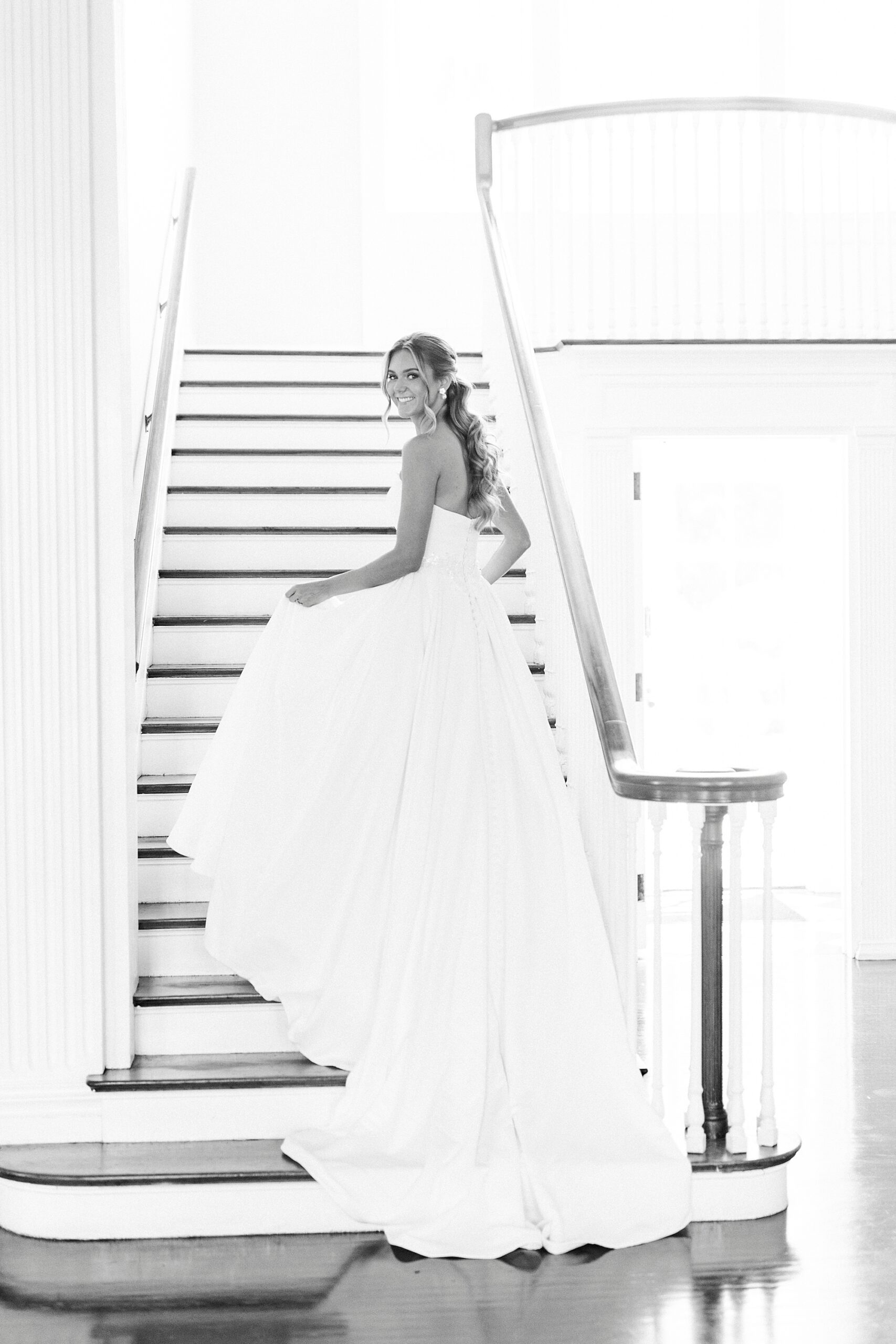 bride holds up skirt walking up steps inside Separk Mansion