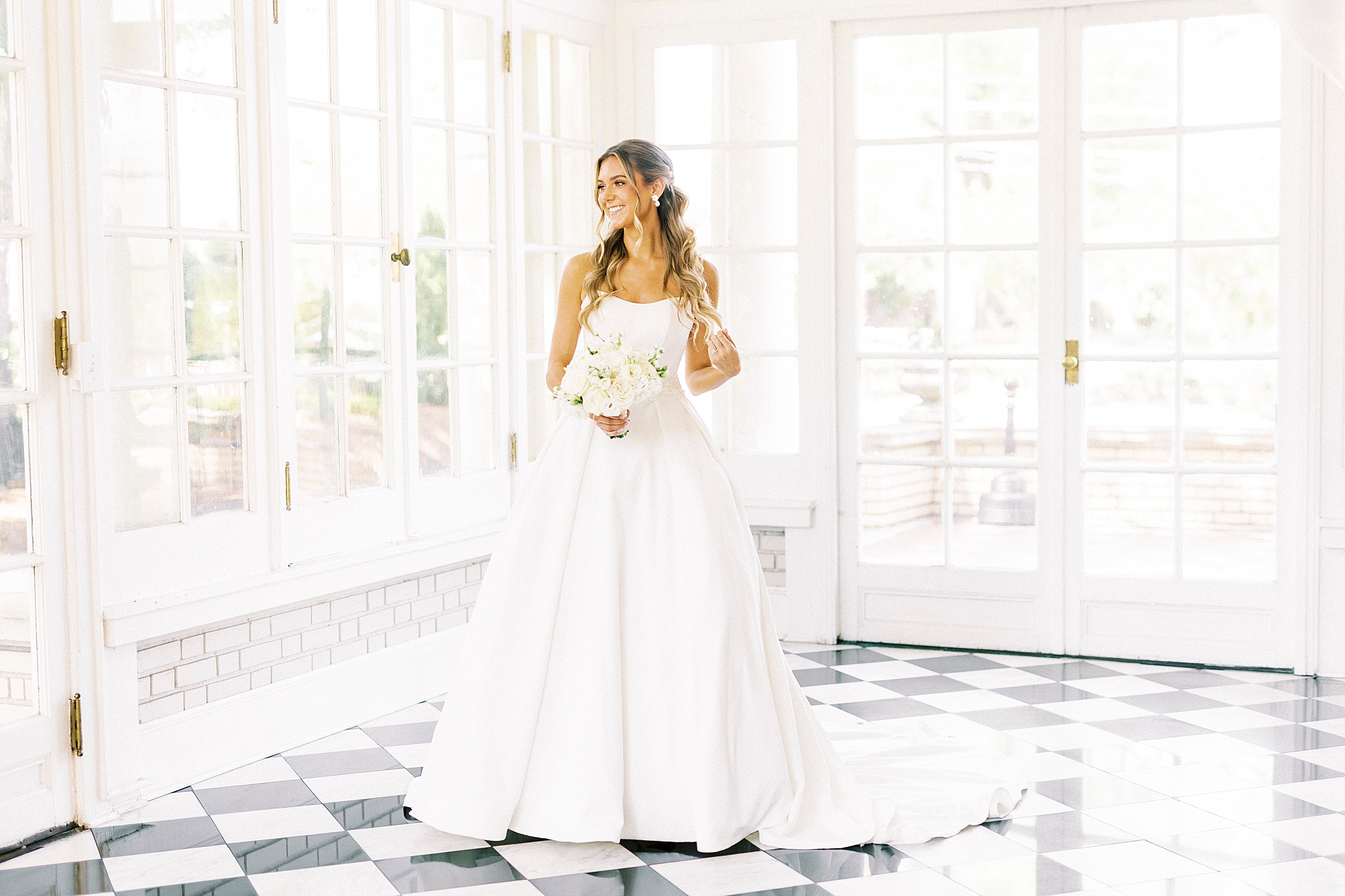 bride smiles looking over shoulder out window in patio room at Separk Mansion