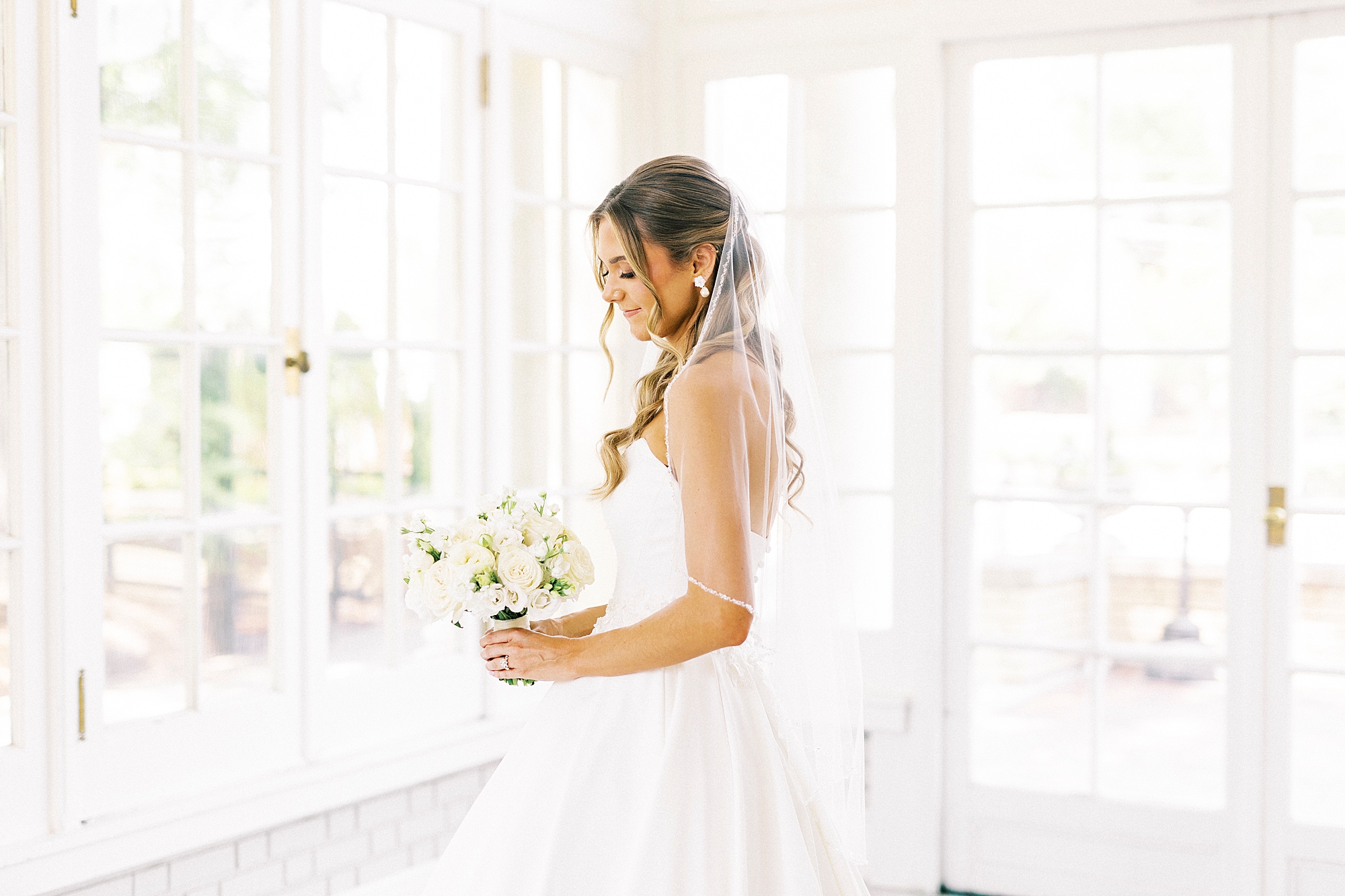 bride holds bouquet of white flowers with veil around her shoulders at Separk Mansion
