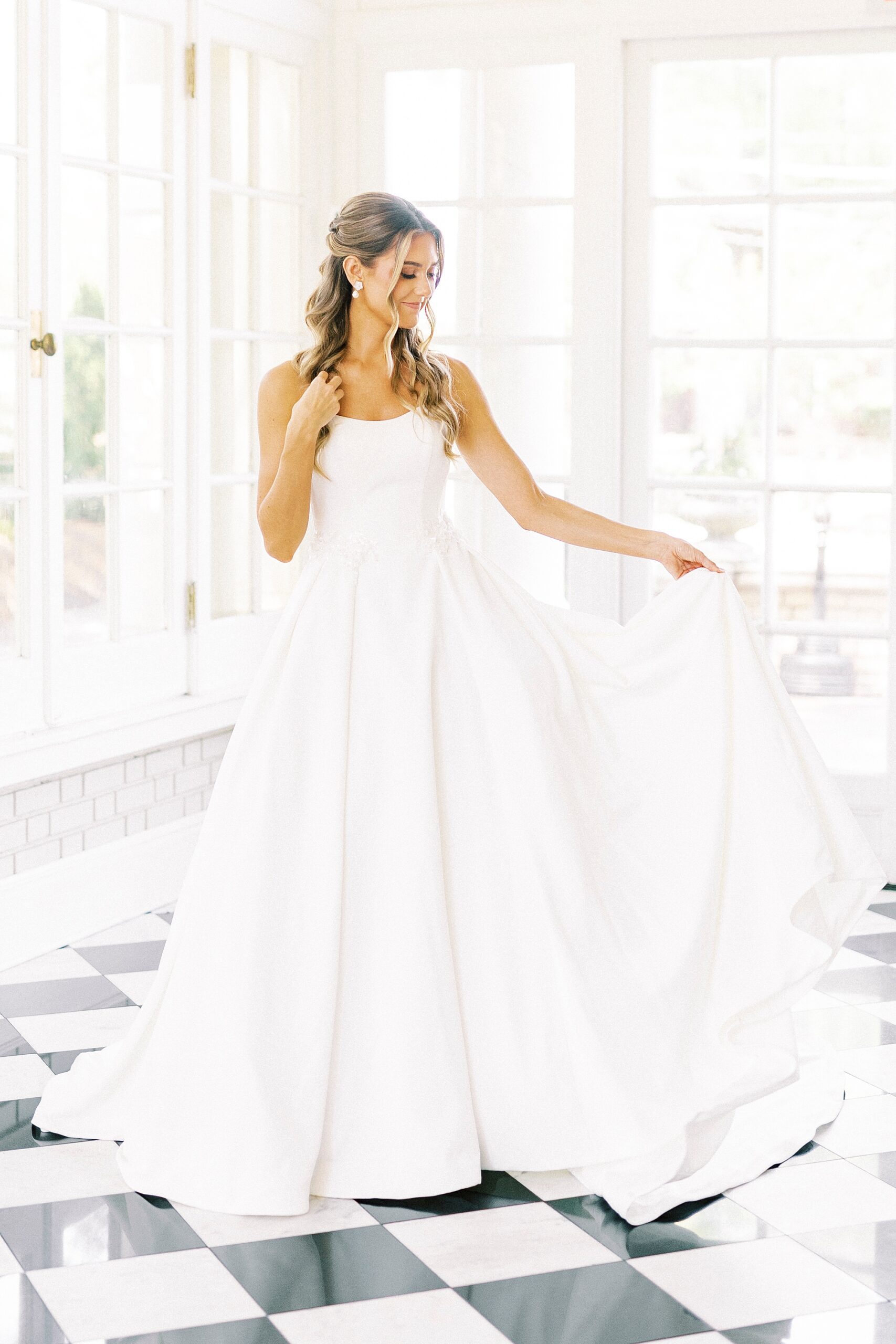 bride holds out skirt on wedding gown on patio at Separk Mansion