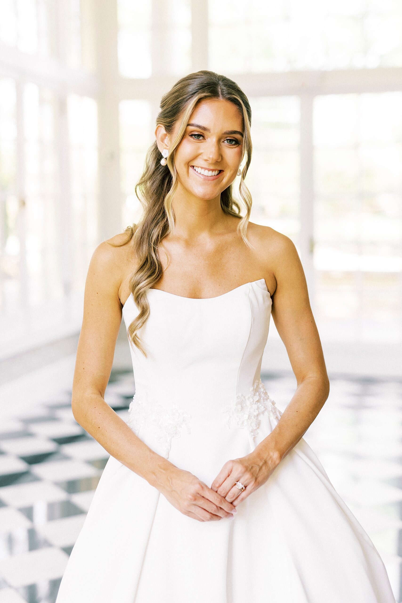 bride stands in strapless gown in sunroom at Separk Mansion