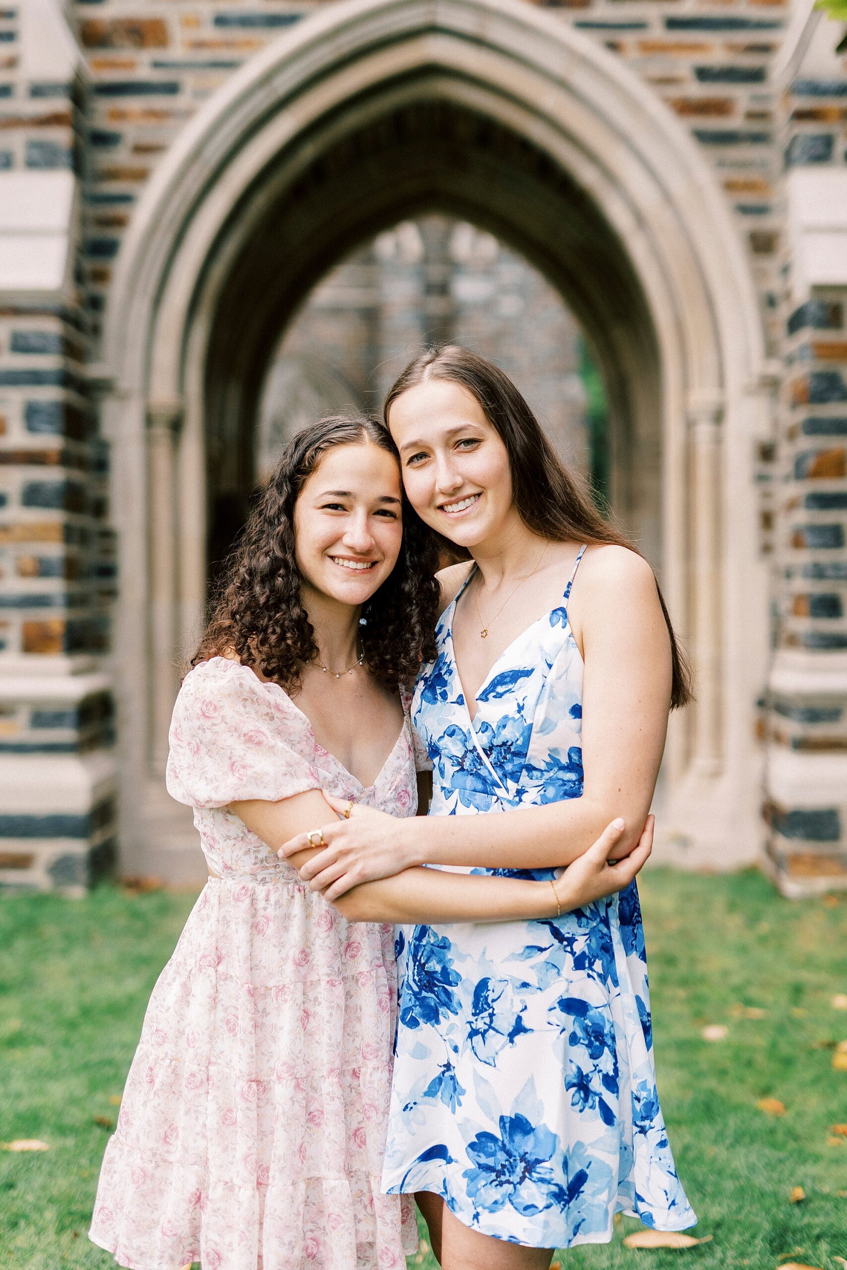 graduate hugs sister during family photos at Duke University
