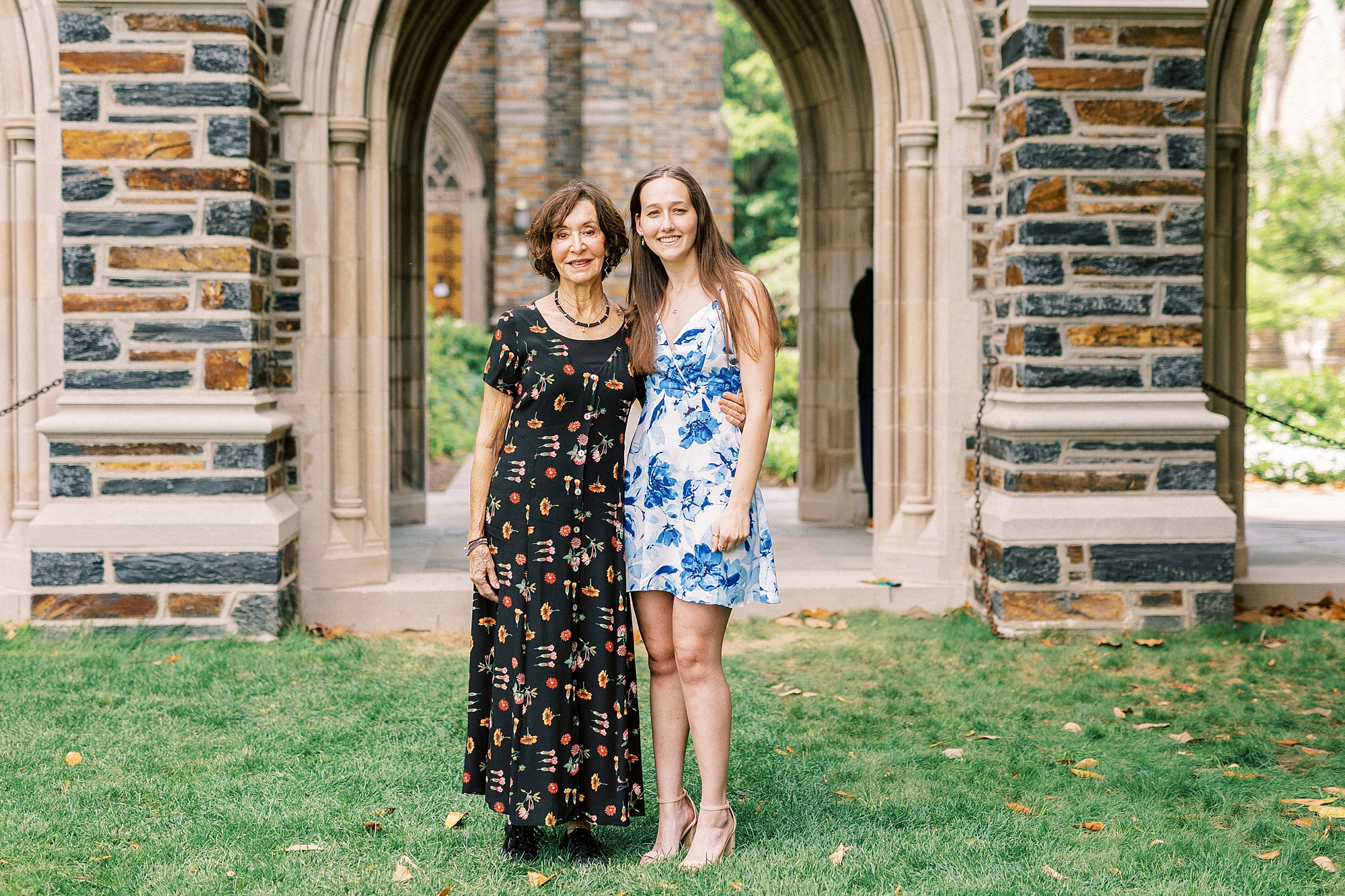 woman in blue and white dress poses with grandmother during family photos at Duke University