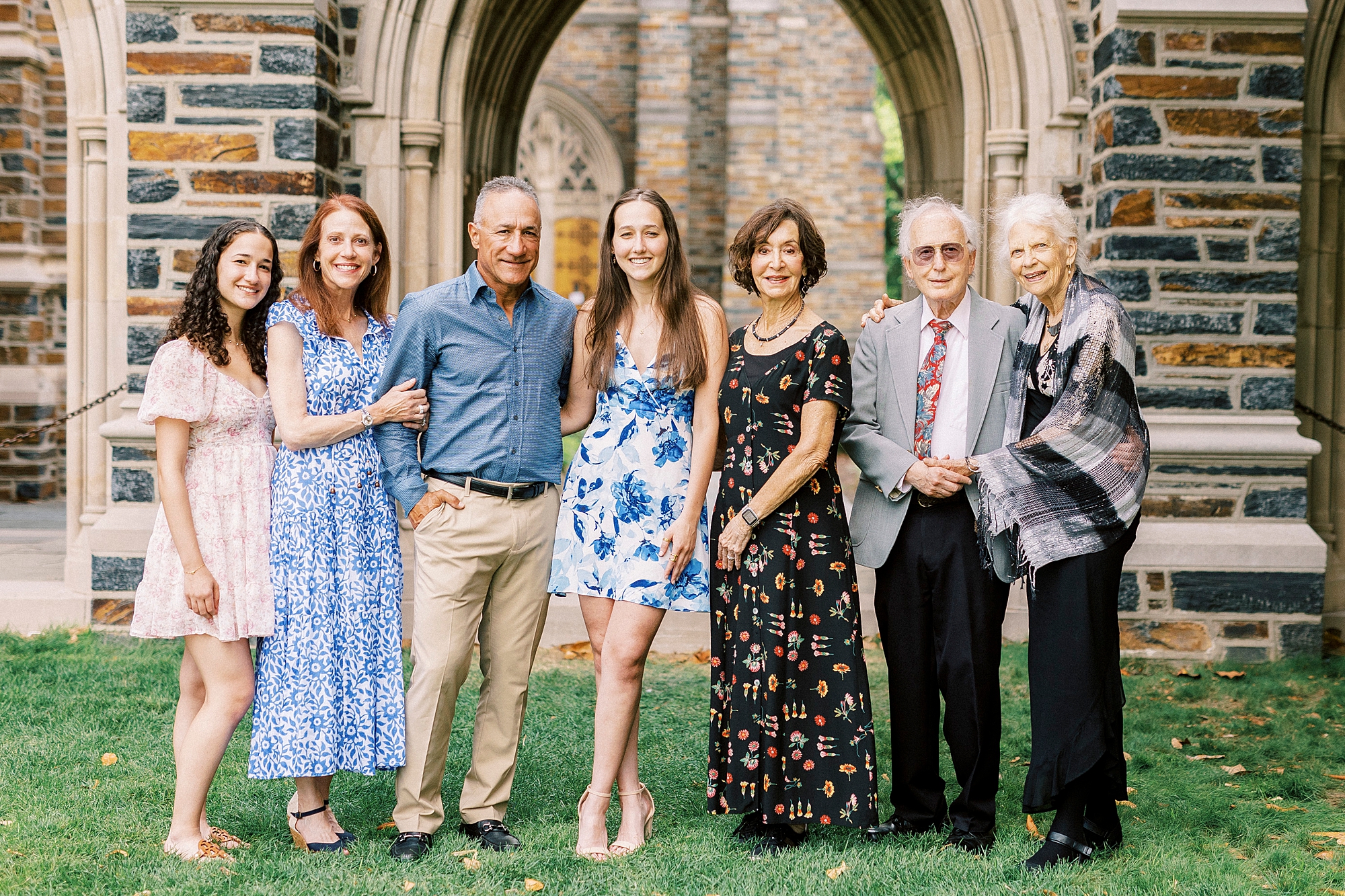 family stands with graduate during family photos at Duke University