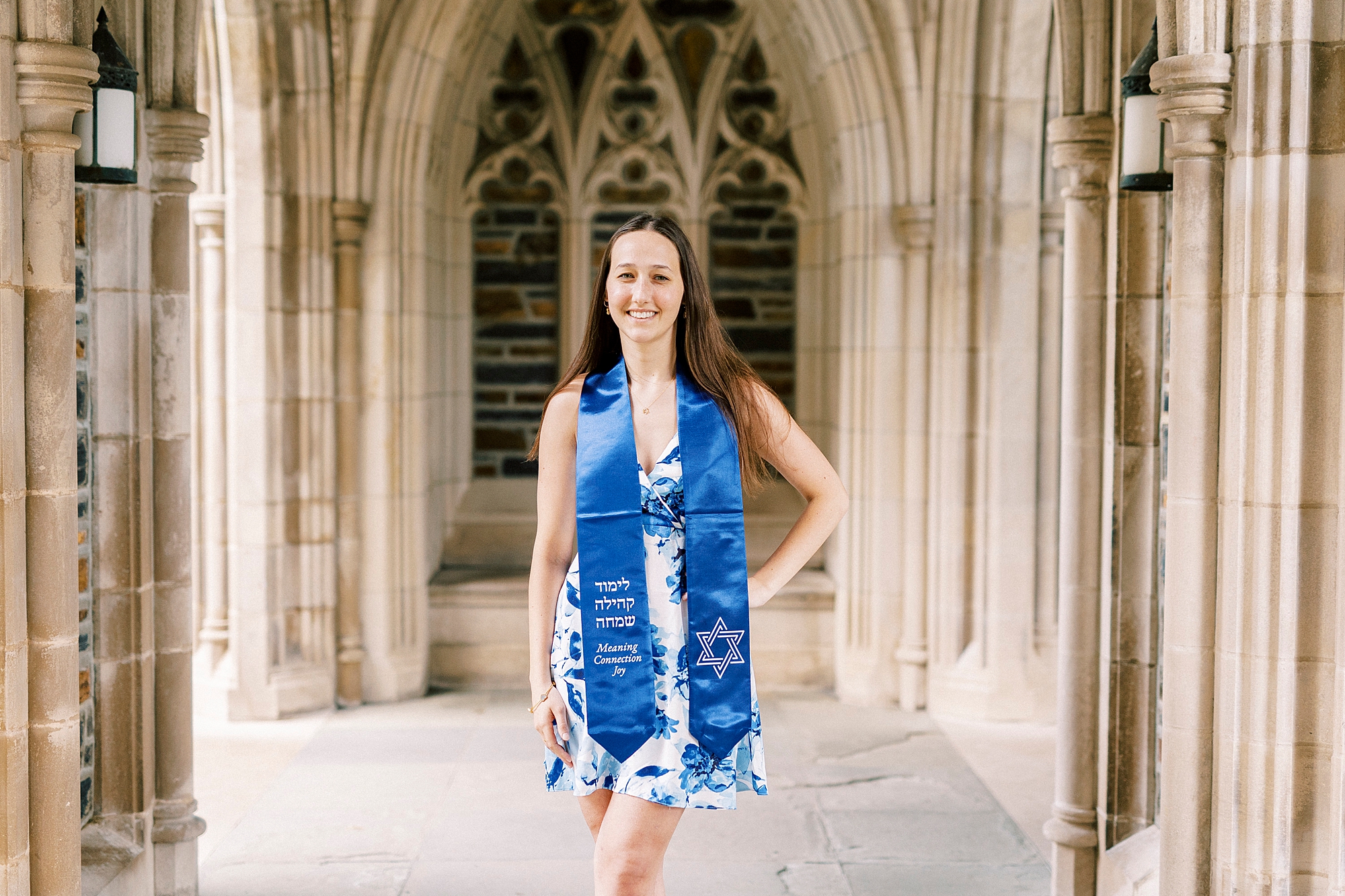 girl poses in blue and white gown with blue sashes 