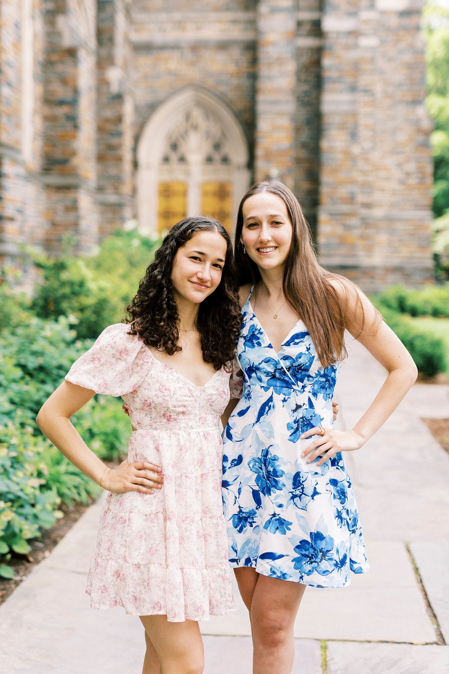 two graduates hug in front of chapel during Duke University senior portraits