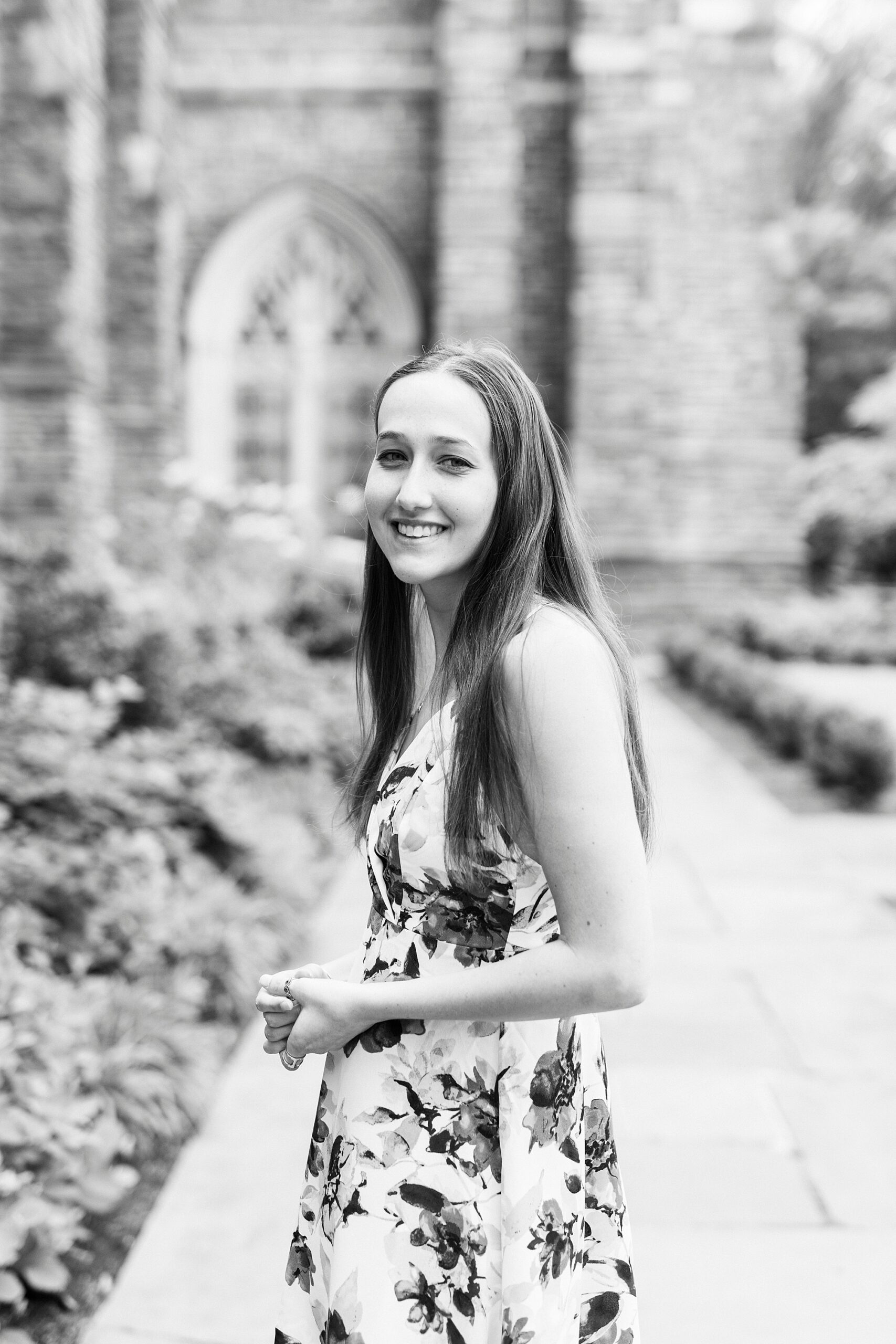 woman smiles over shoulder walking away from chapel at Duke University