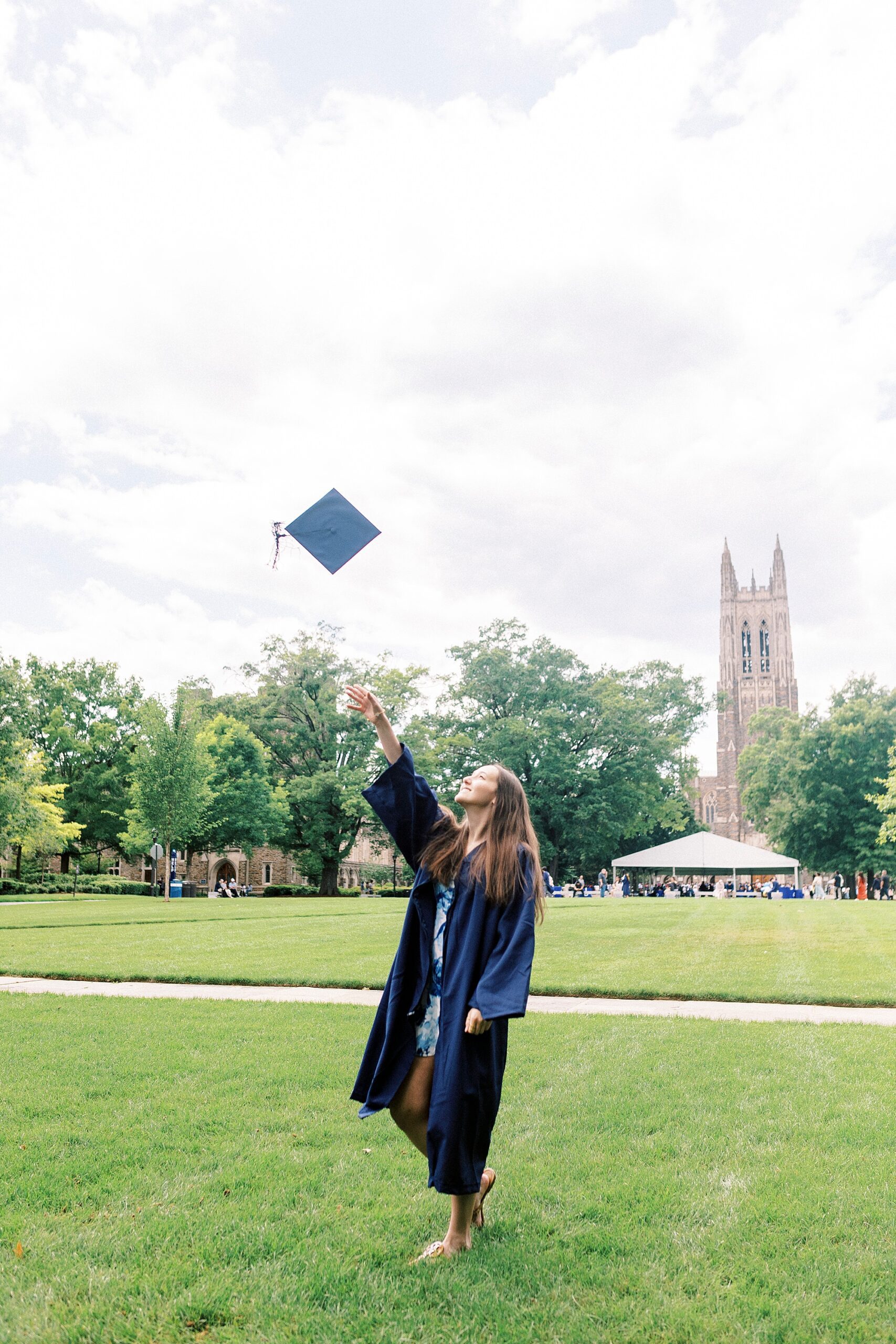 graduate tosses cap in the air during Duke University senior portraits