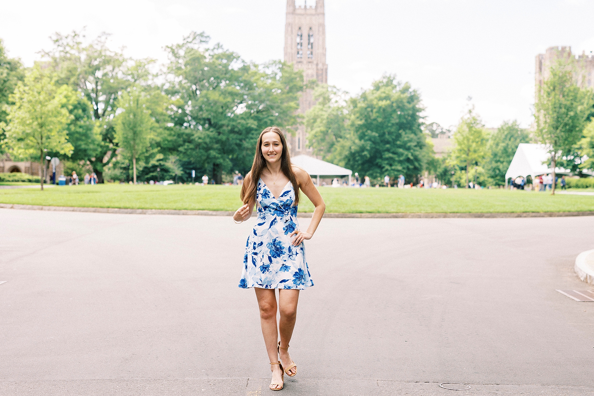 senior poses in blue and white gown during Duke University senior portraits