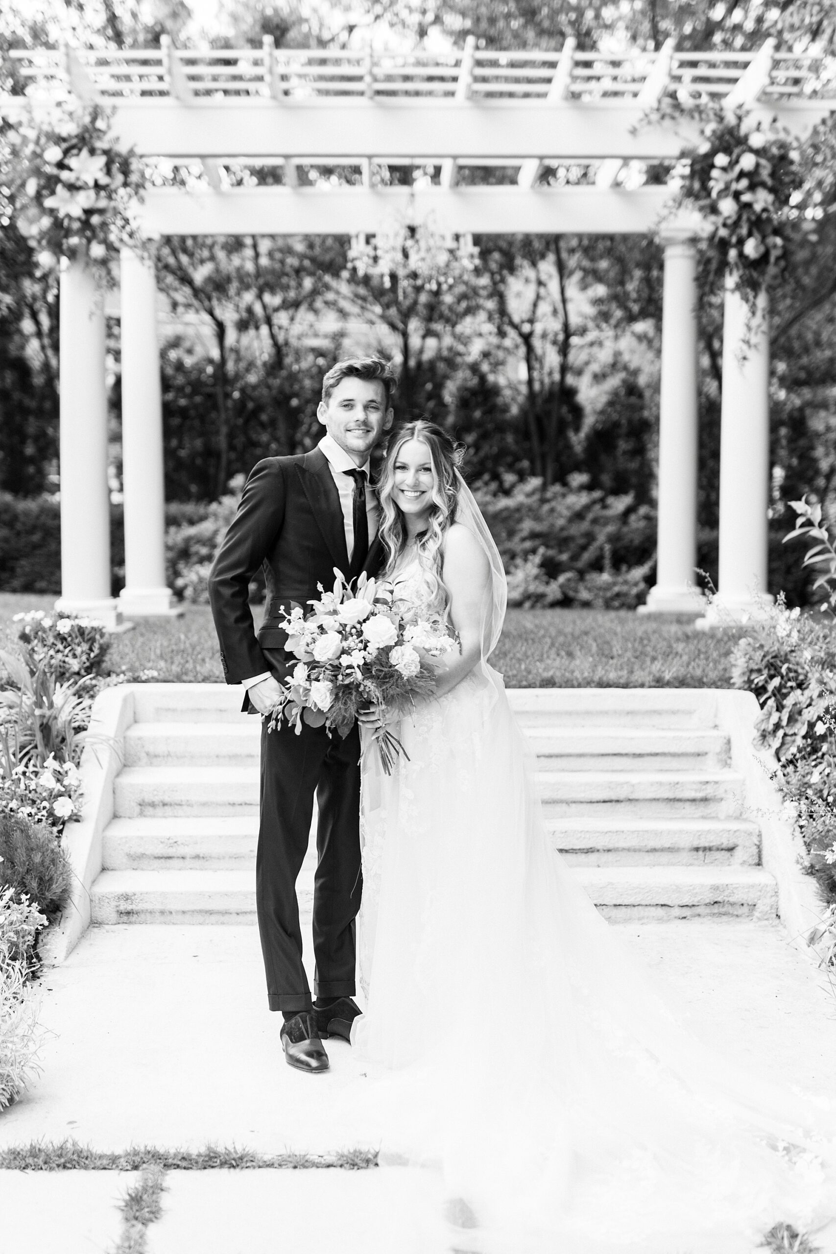 newlyweds hug in front of ceremony site in garden at Separk Mansion