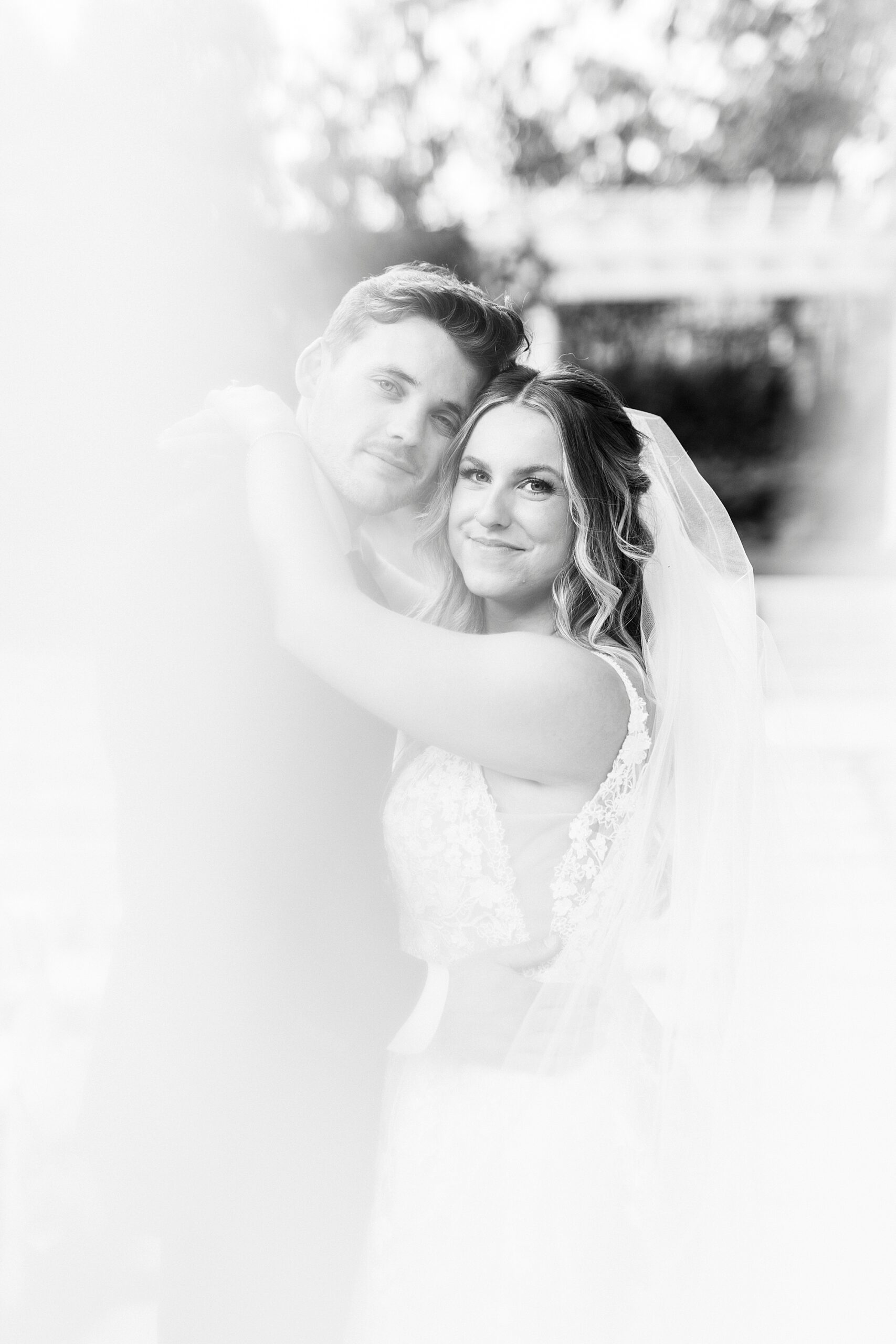 bride and groom hug with veil obscuring camera in garden at Separk Mansion