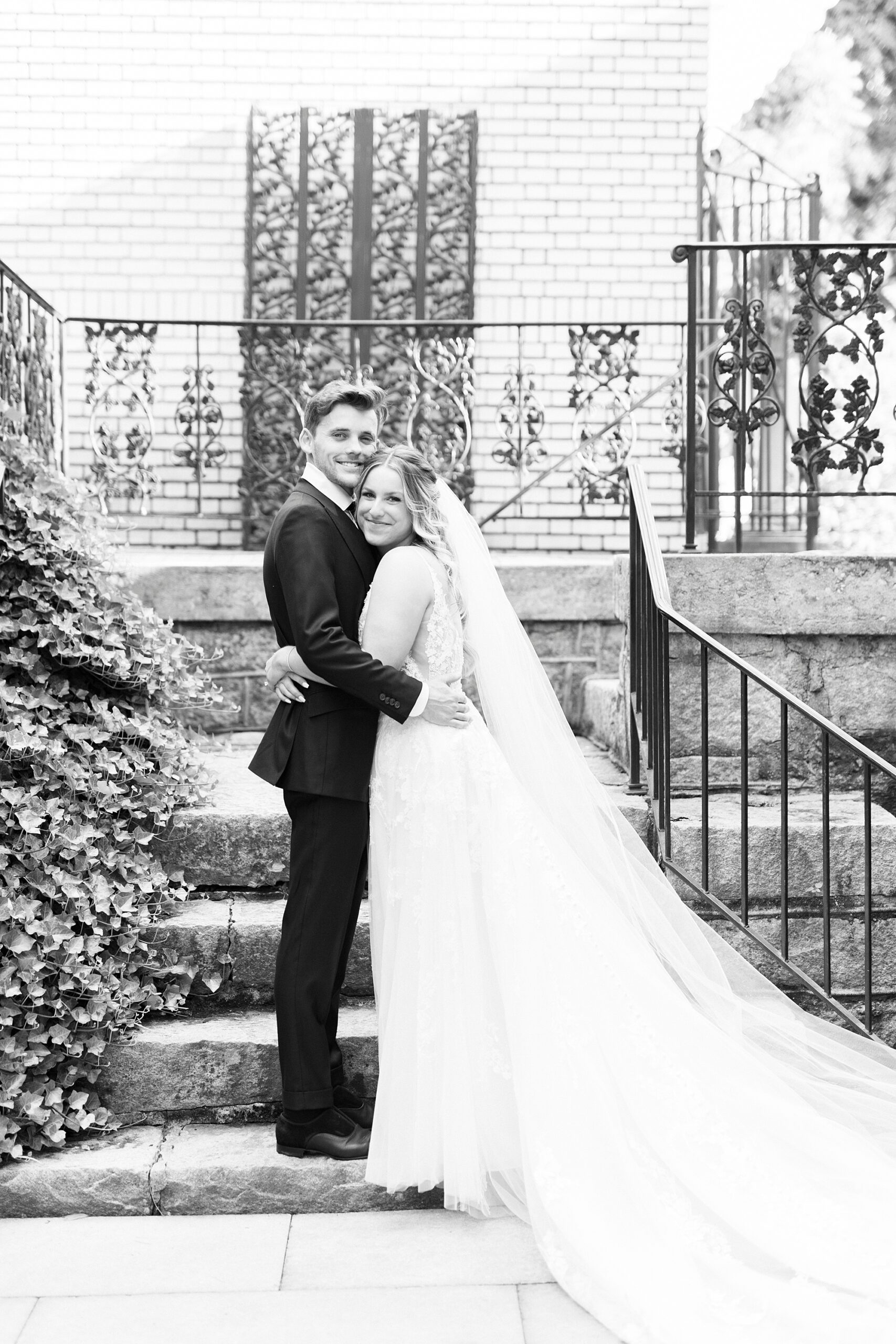 newlyweds hug in front of stone staircase inside Separk Mansion