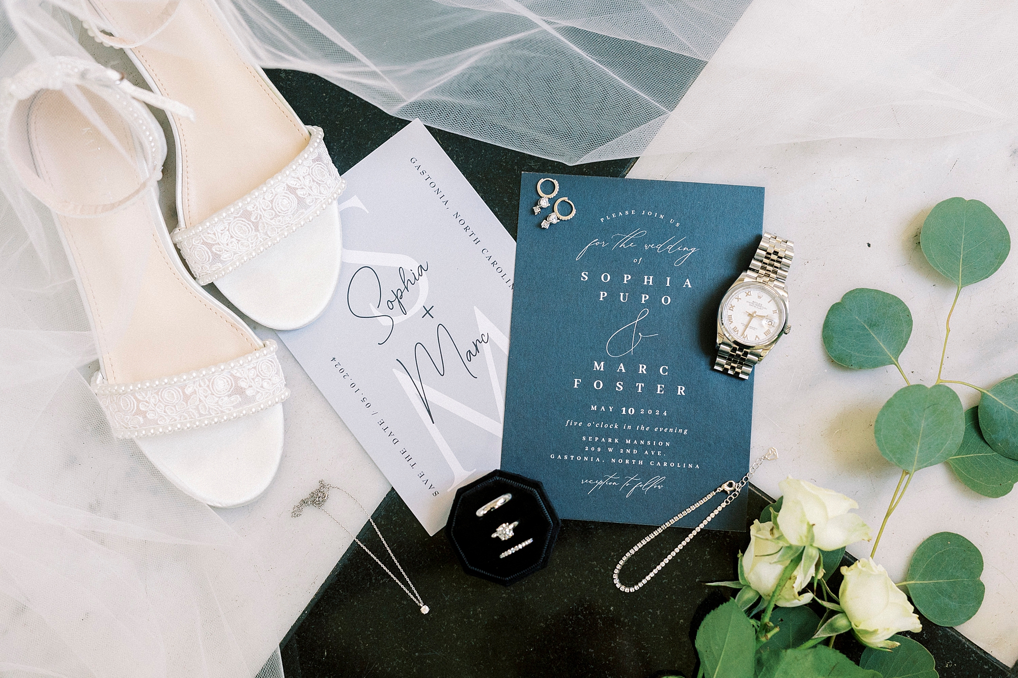 white and blue wedding invitation on black and white floor at Separk Mansion