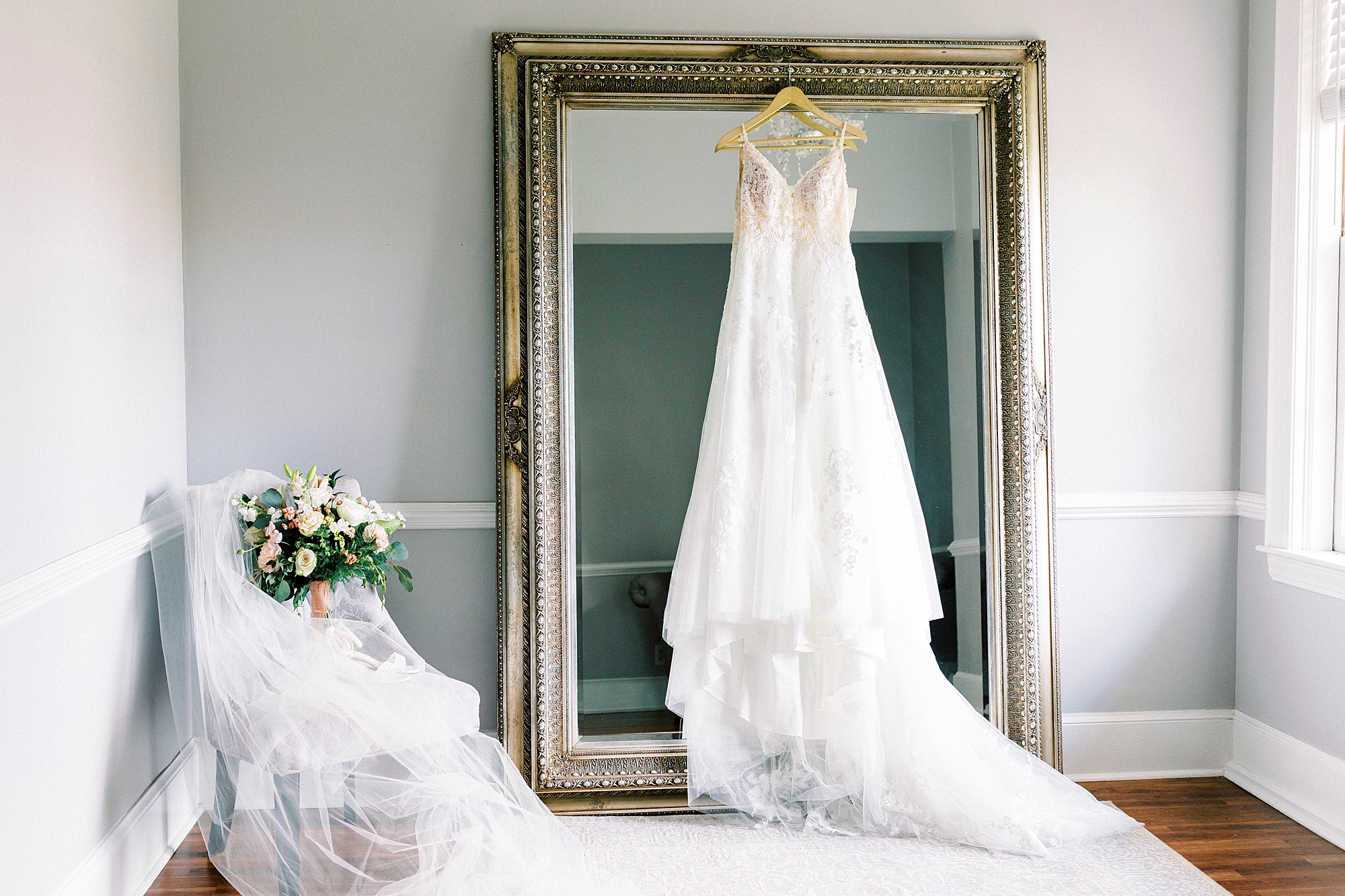 wedding dress hangs on gold frame in suite at Separk Mansion