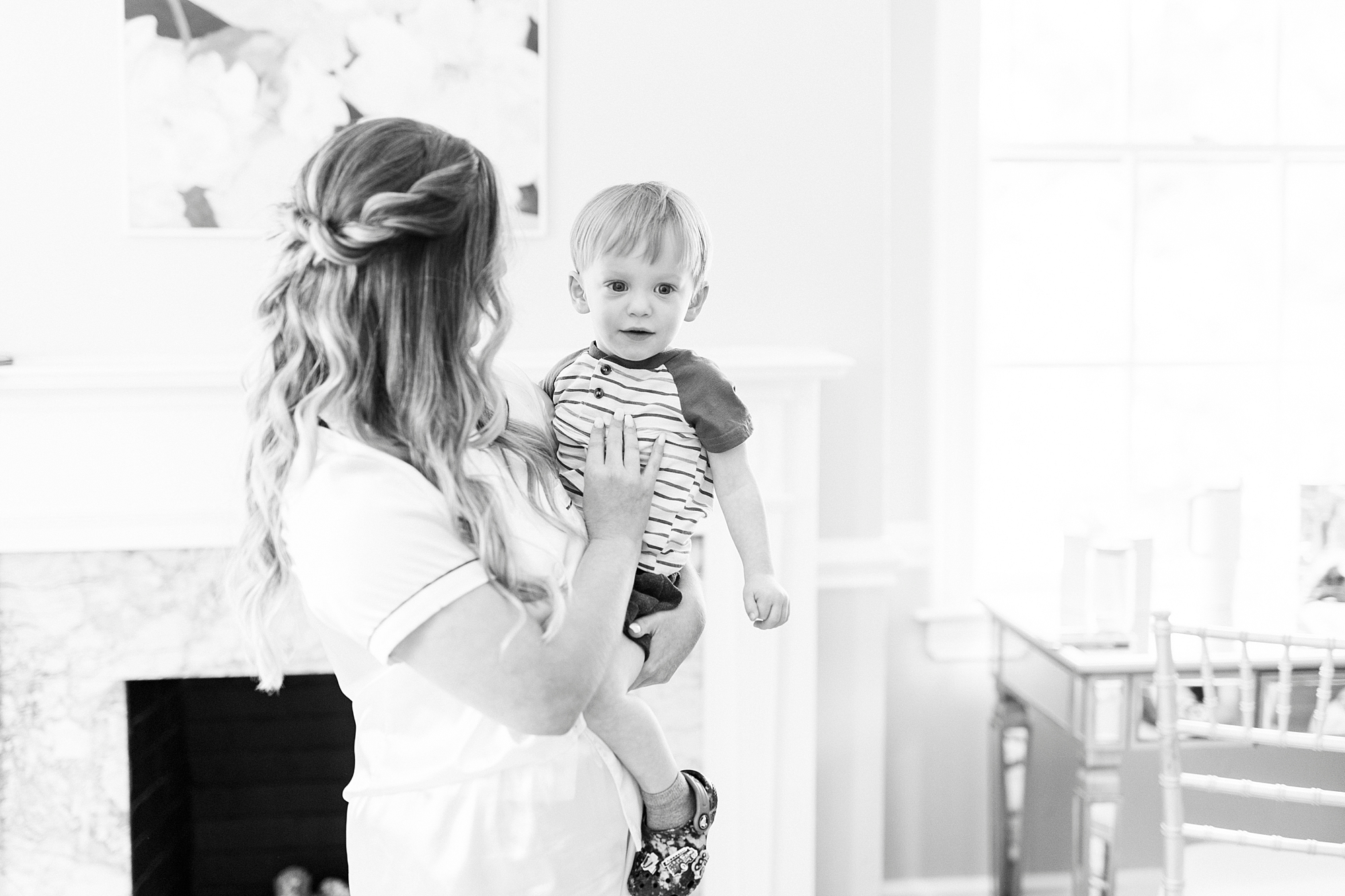bride holds son on hip during prep for NC wedding day