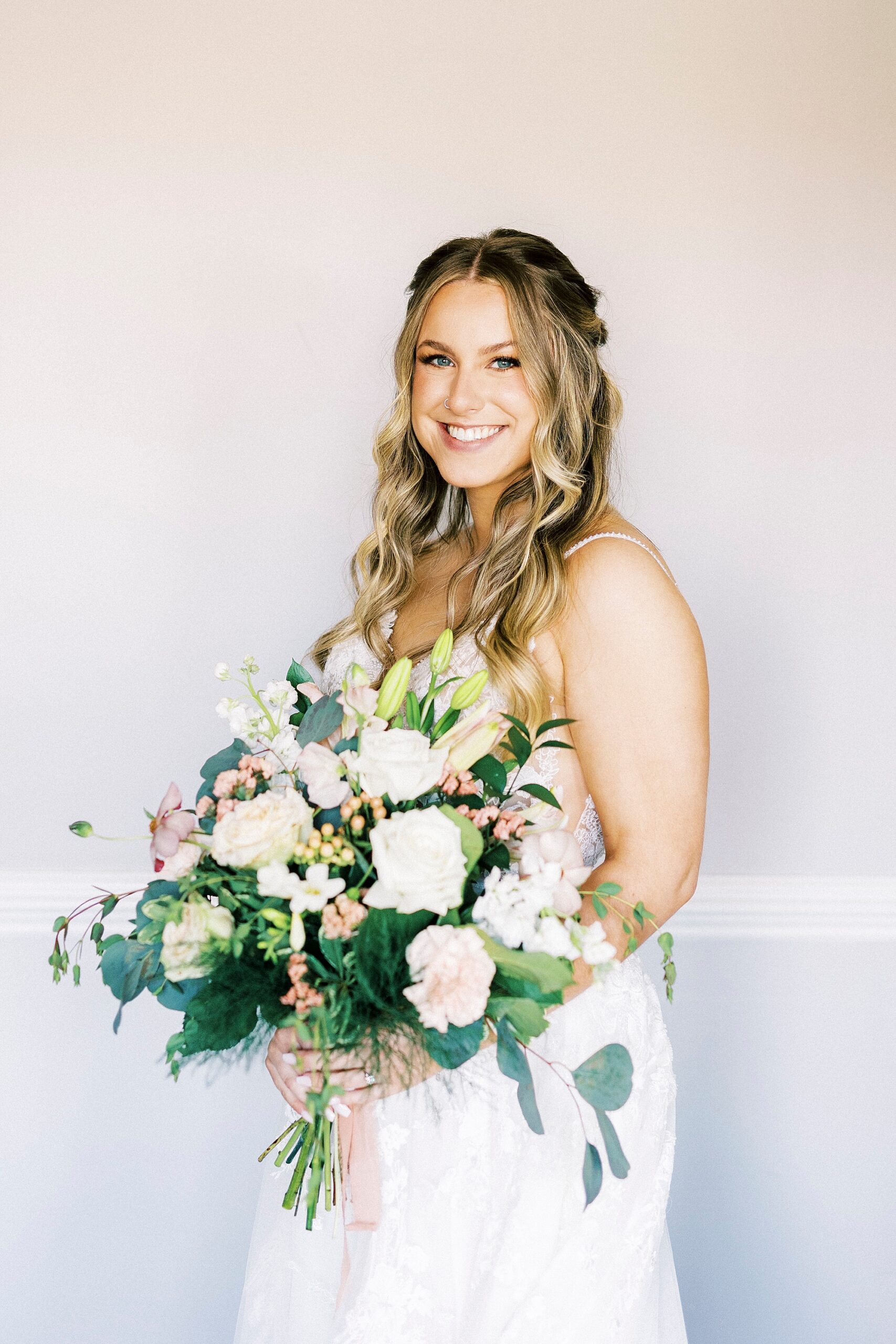 bride holds bouquet of white and pink flowers for spring wedding at Separk Mansion