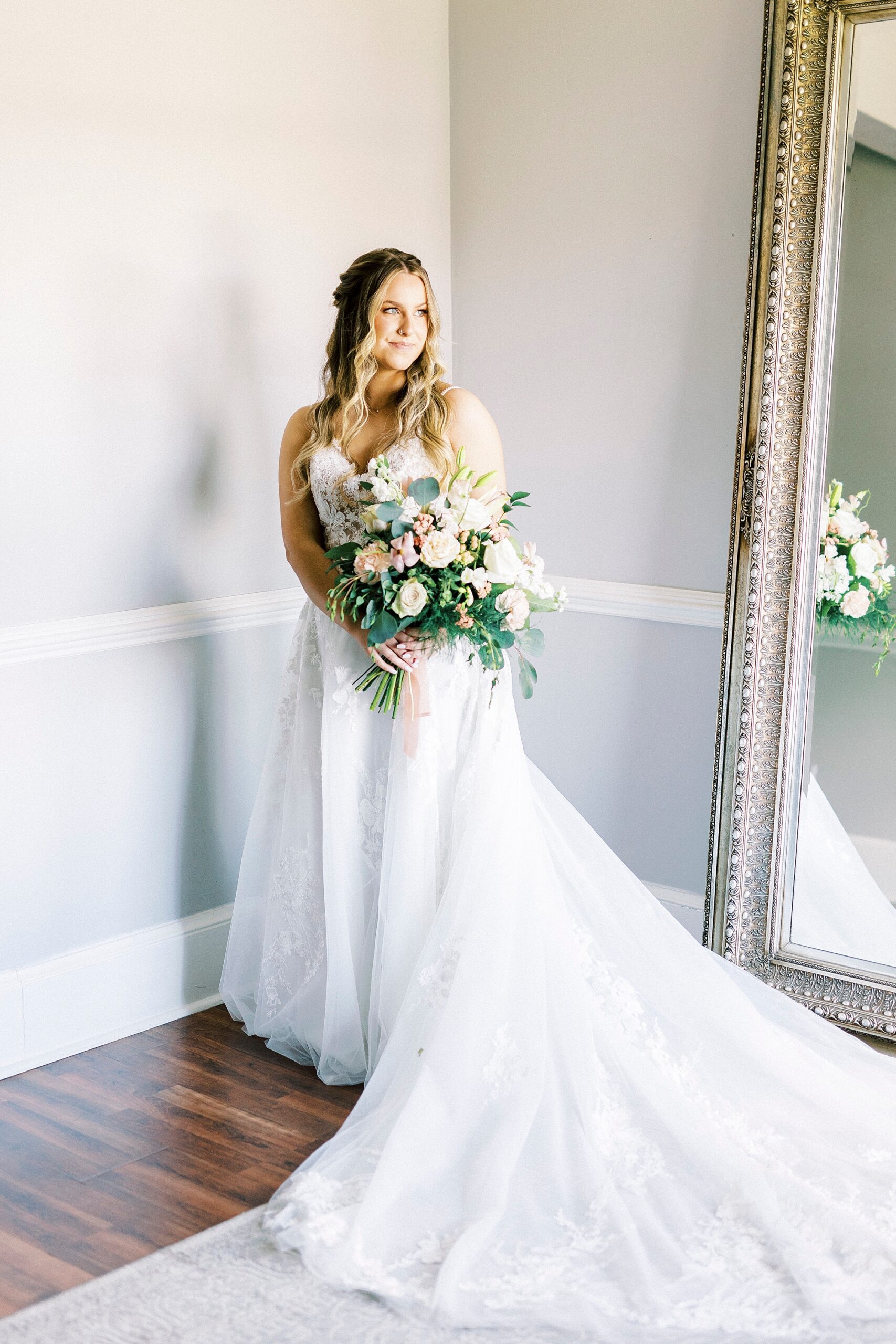 bride holds bouquet of white flowers in corner of suite at Separk Mansion