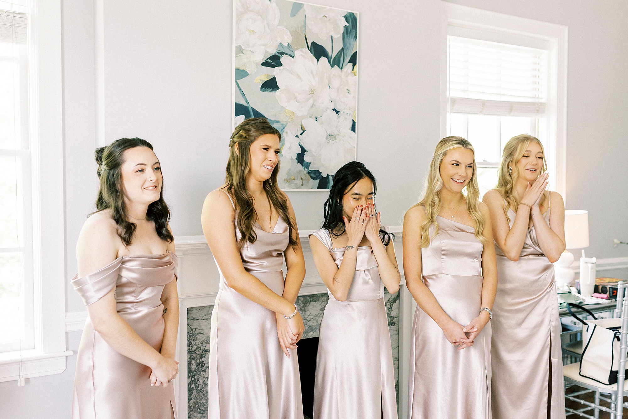 bridesmaids in satin gowns cry during first look with bride 