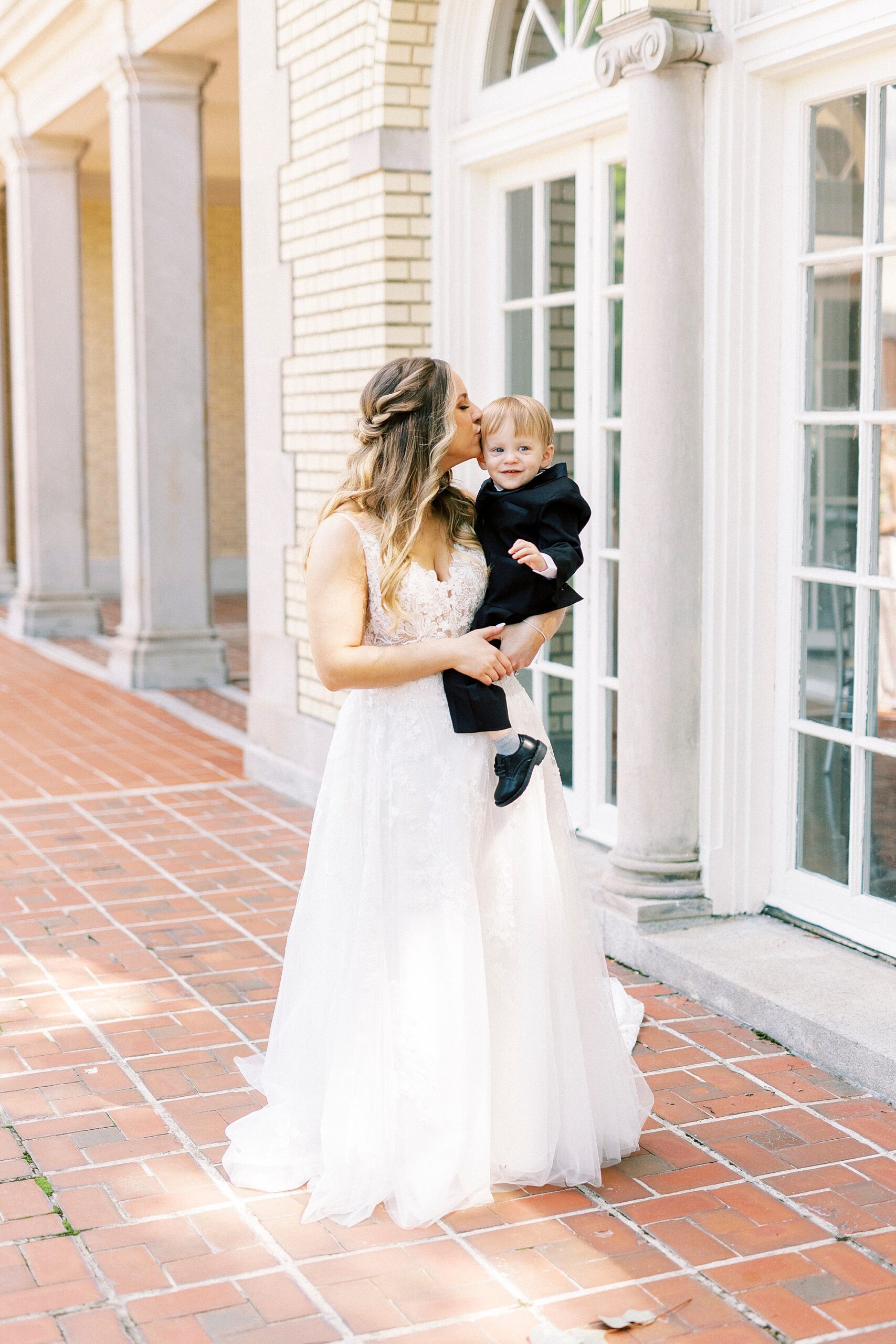 bride poses with son on hip during NC wedding day