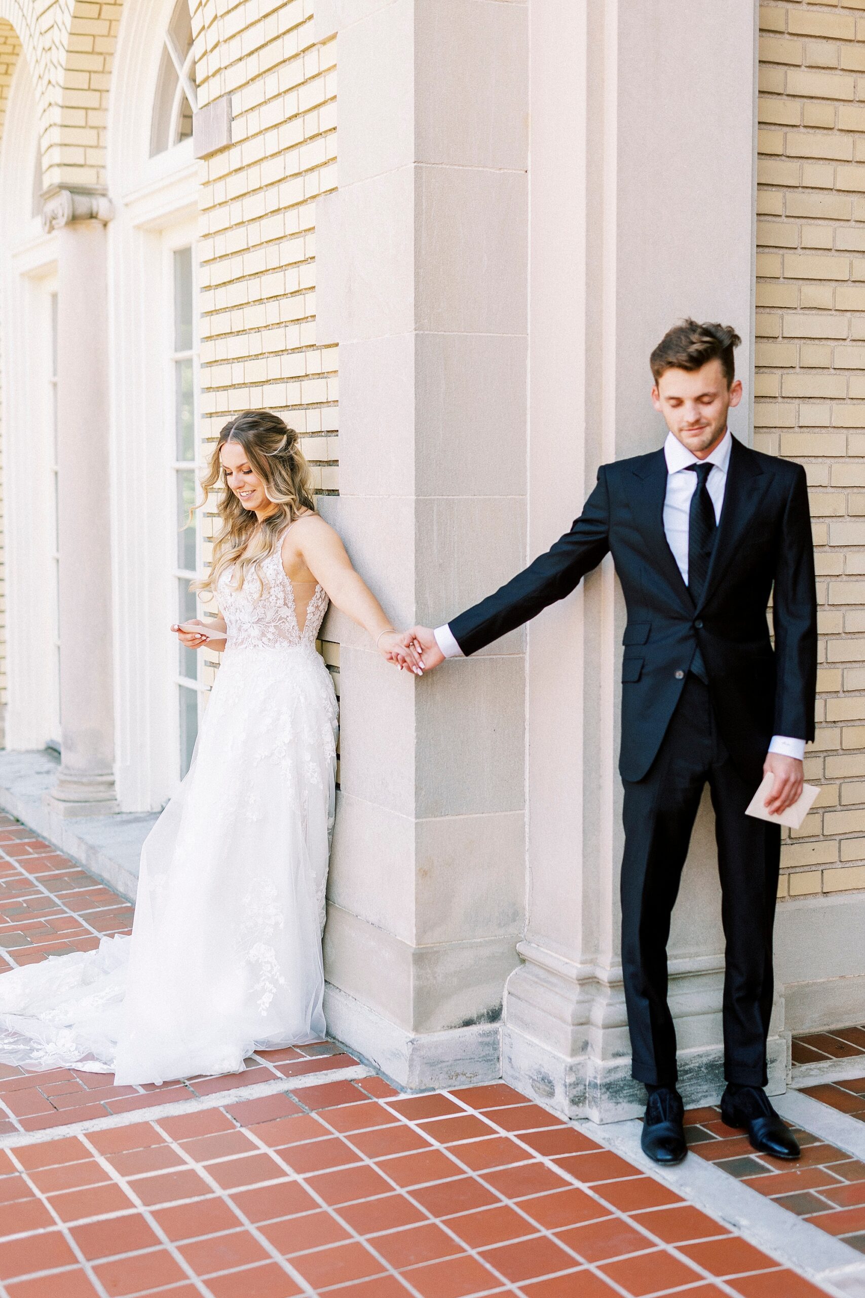 couple holds hands around corner of Separk Mansion