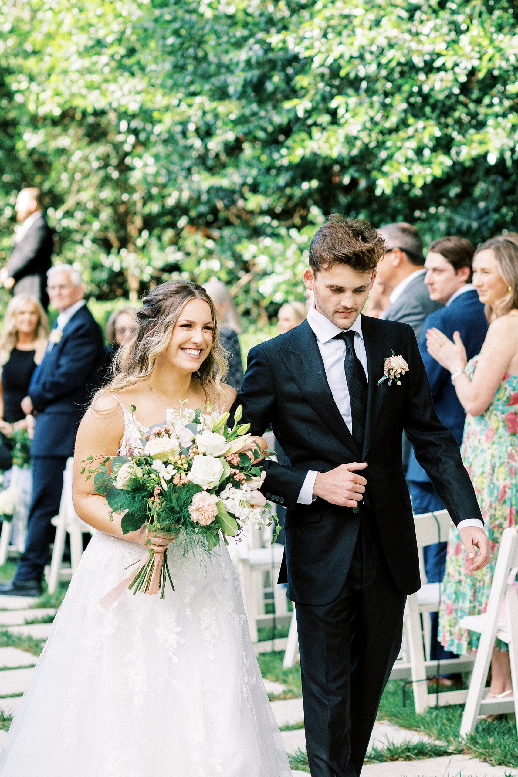 newlyweds smile leaving garden wedding ceremony at Separk Mansion