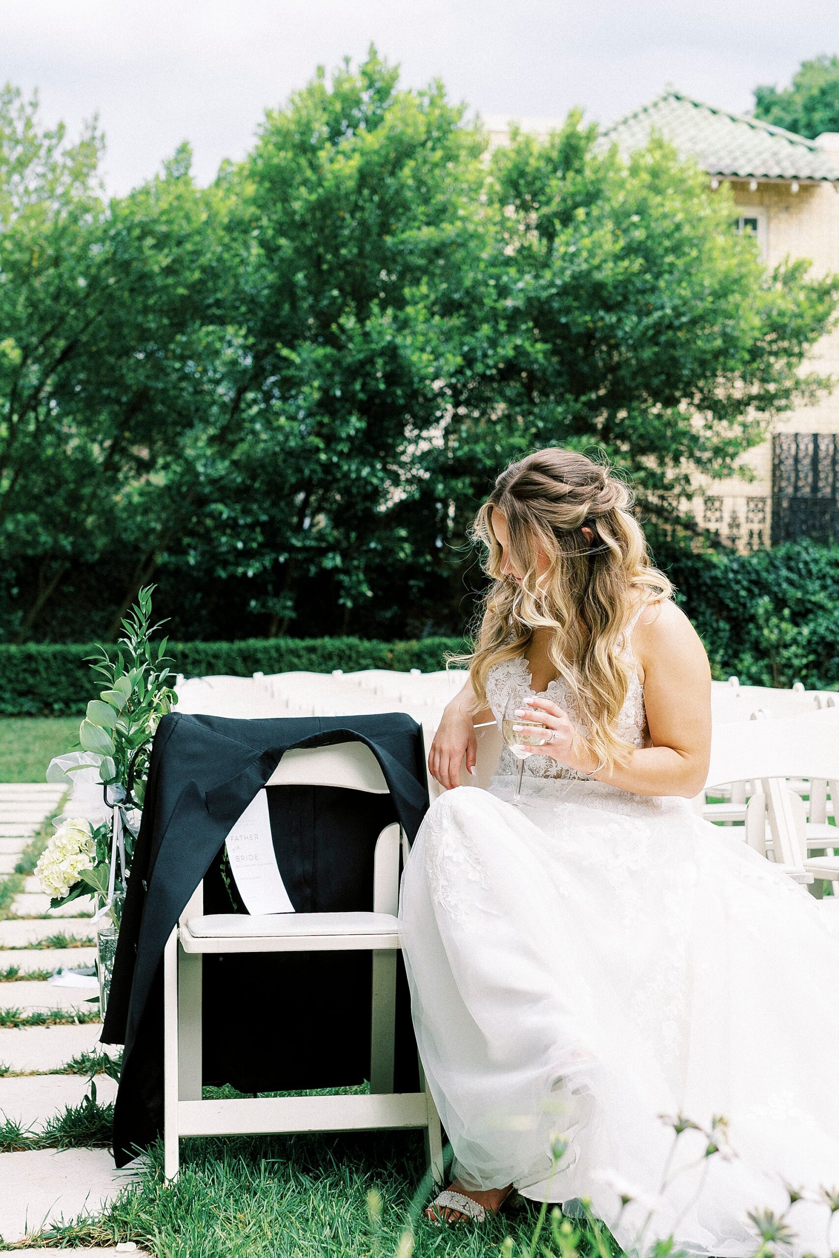 bride sits with memorial chair for her father 