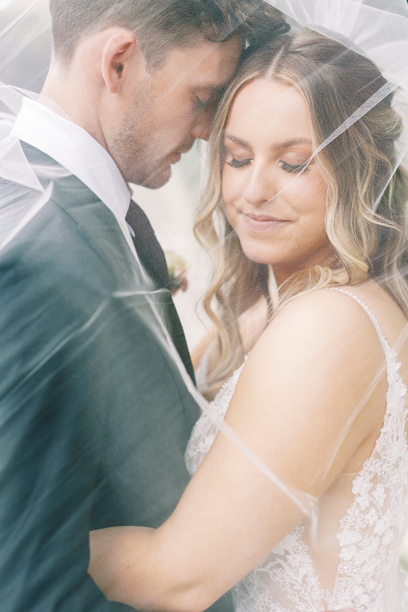 groom nuzzles bride's cheek under veil in North Carolina 