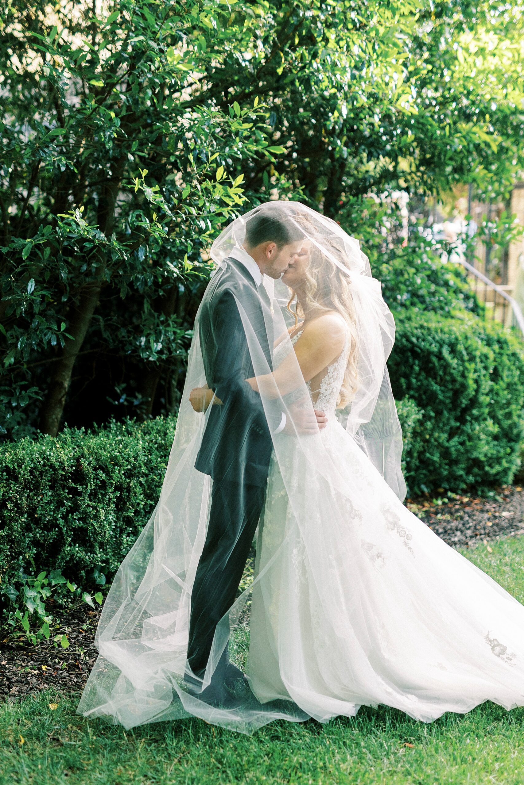 bride and groom hug under bride's veil in garden of Separk Mansion