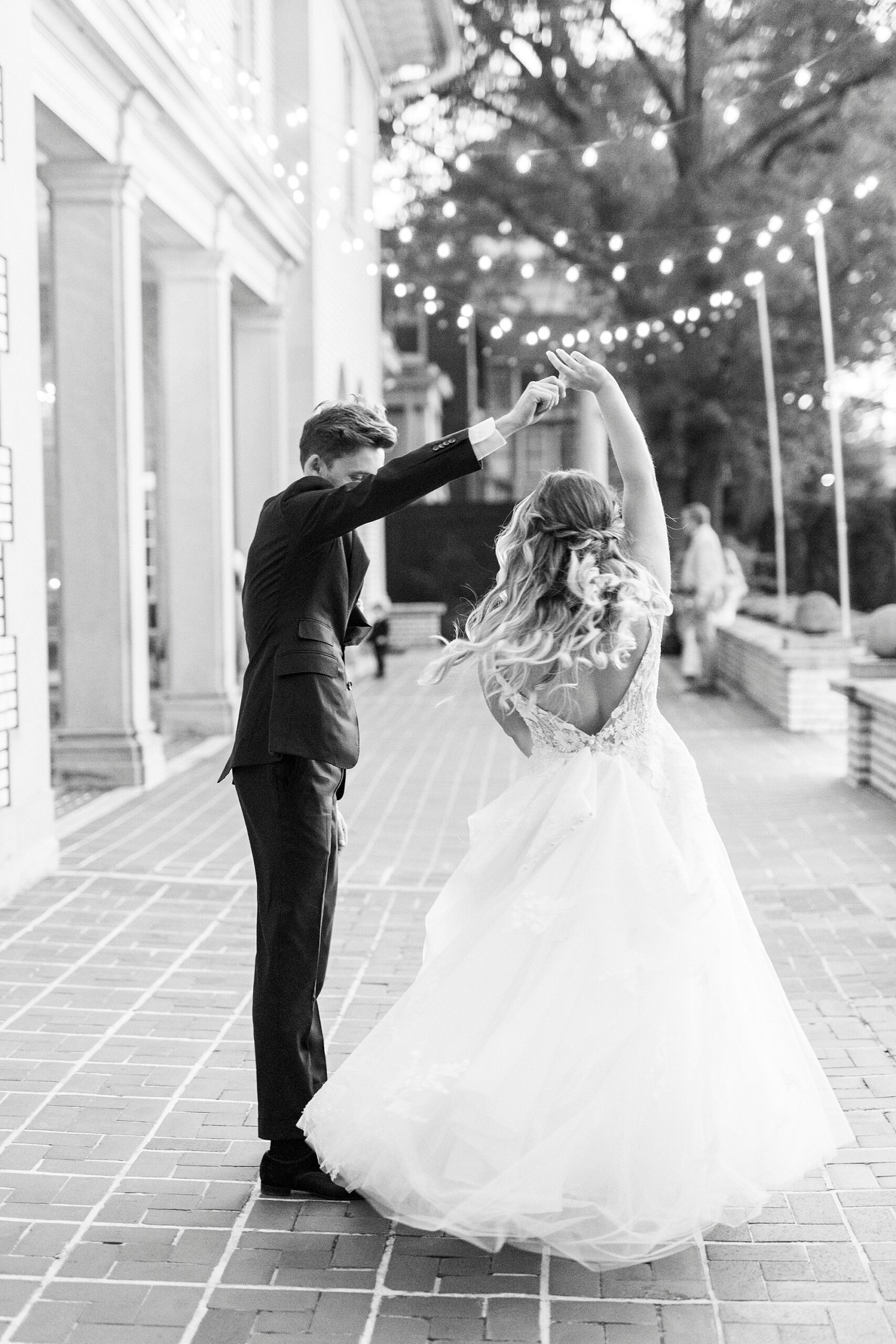 groom twirls bride on patio during Charlotte NC wedding reception