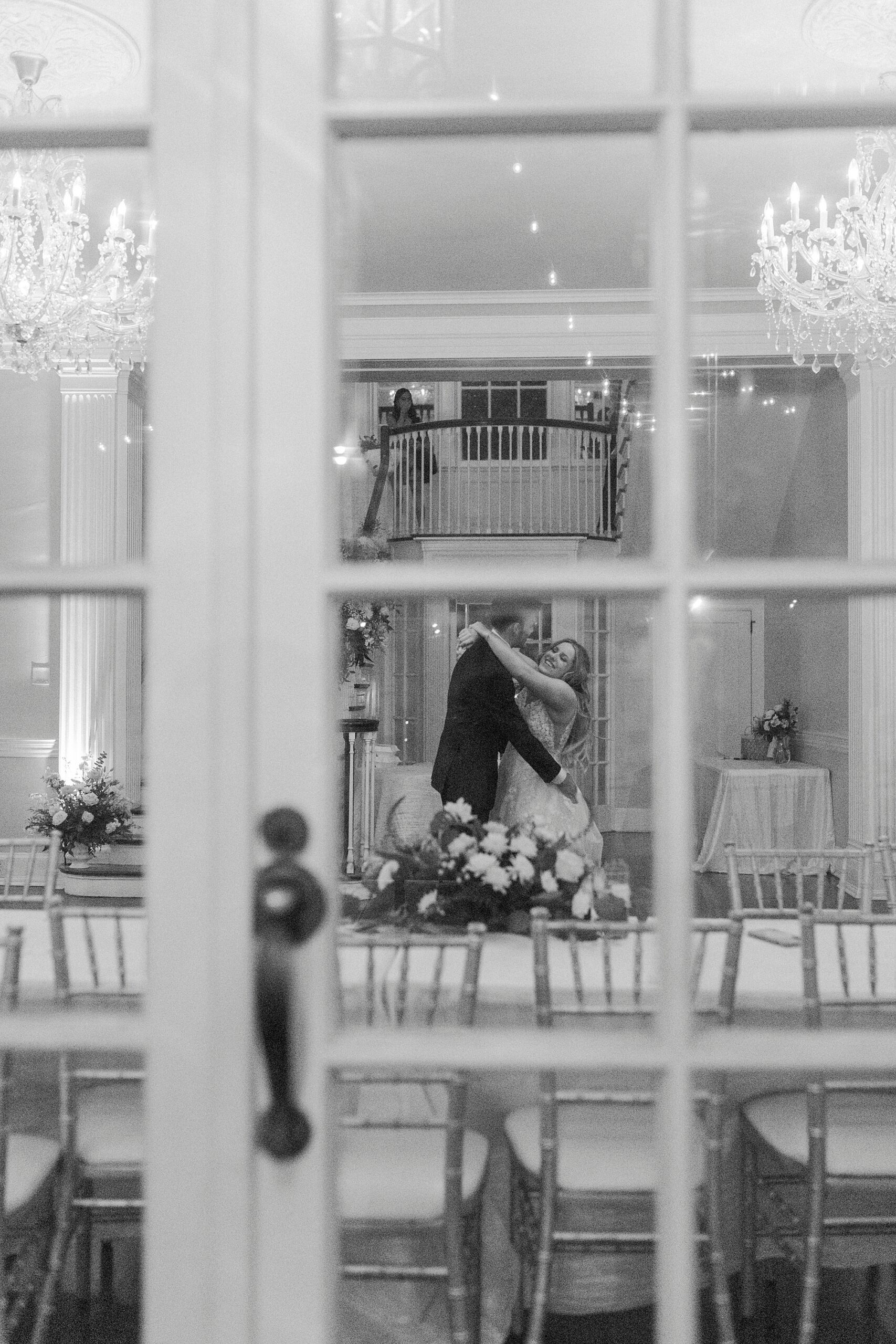 newlyweds hug photographed through pane of window