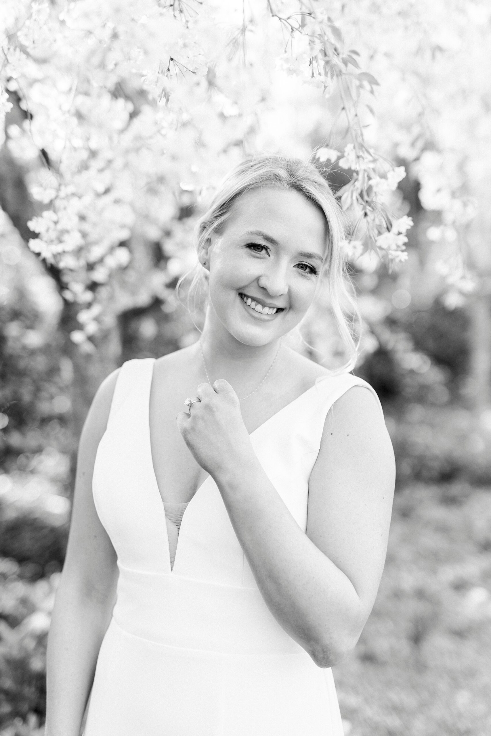 bride grins holding necklace in wedding gown