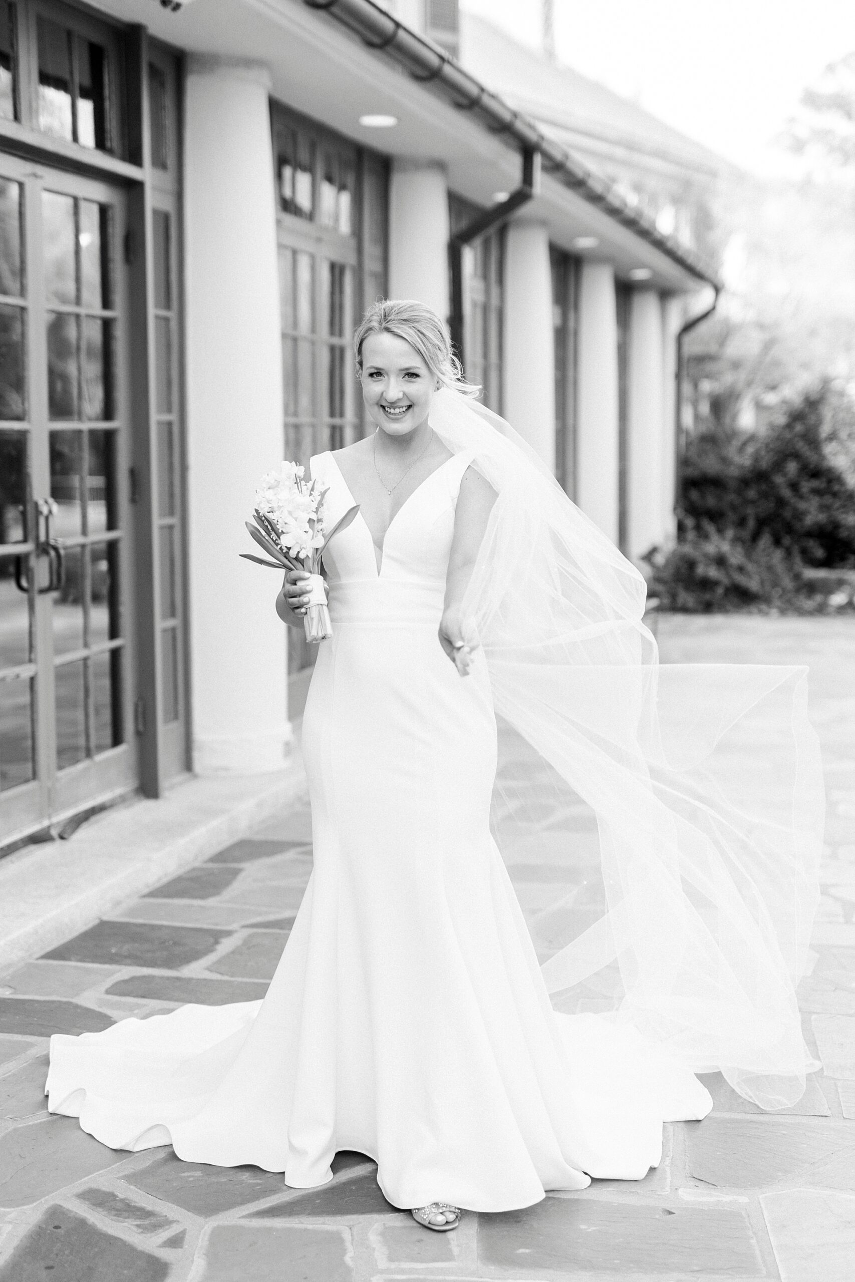 bride stands on walkway at Reynolda Gardens with veil around her