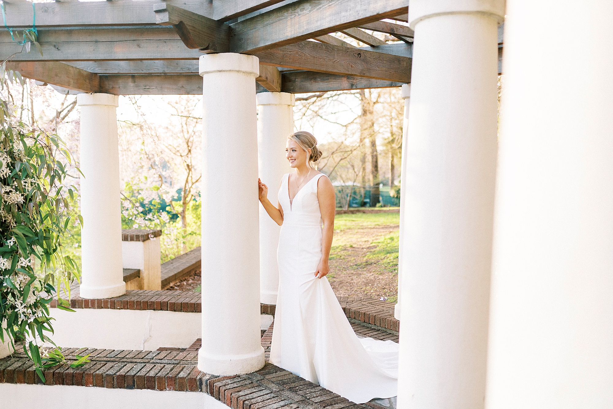 bride leans against pillar at Reynolda Gardens
