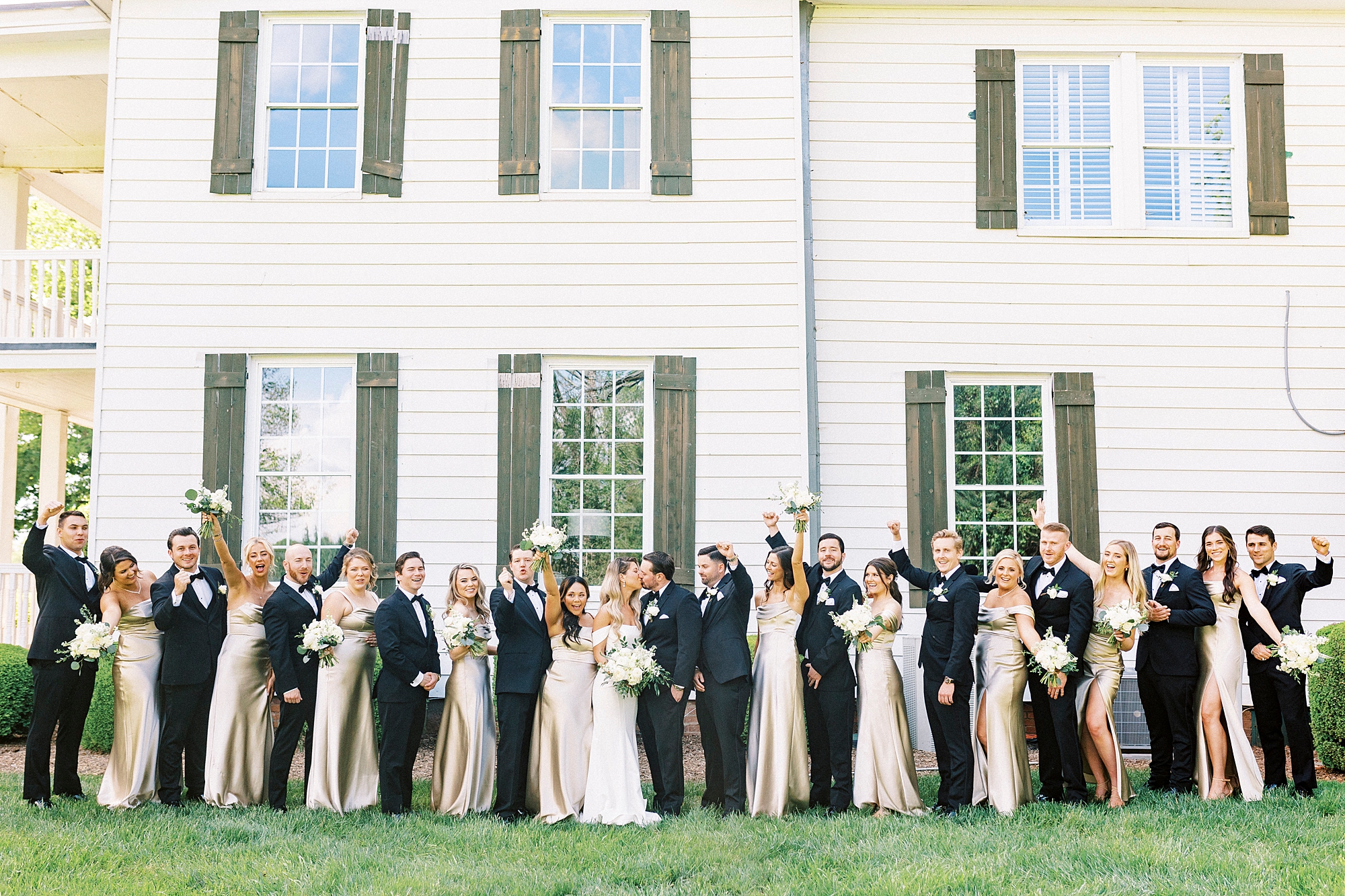 newlyweds pose with wedding party cheering outside the Venues at Langtree