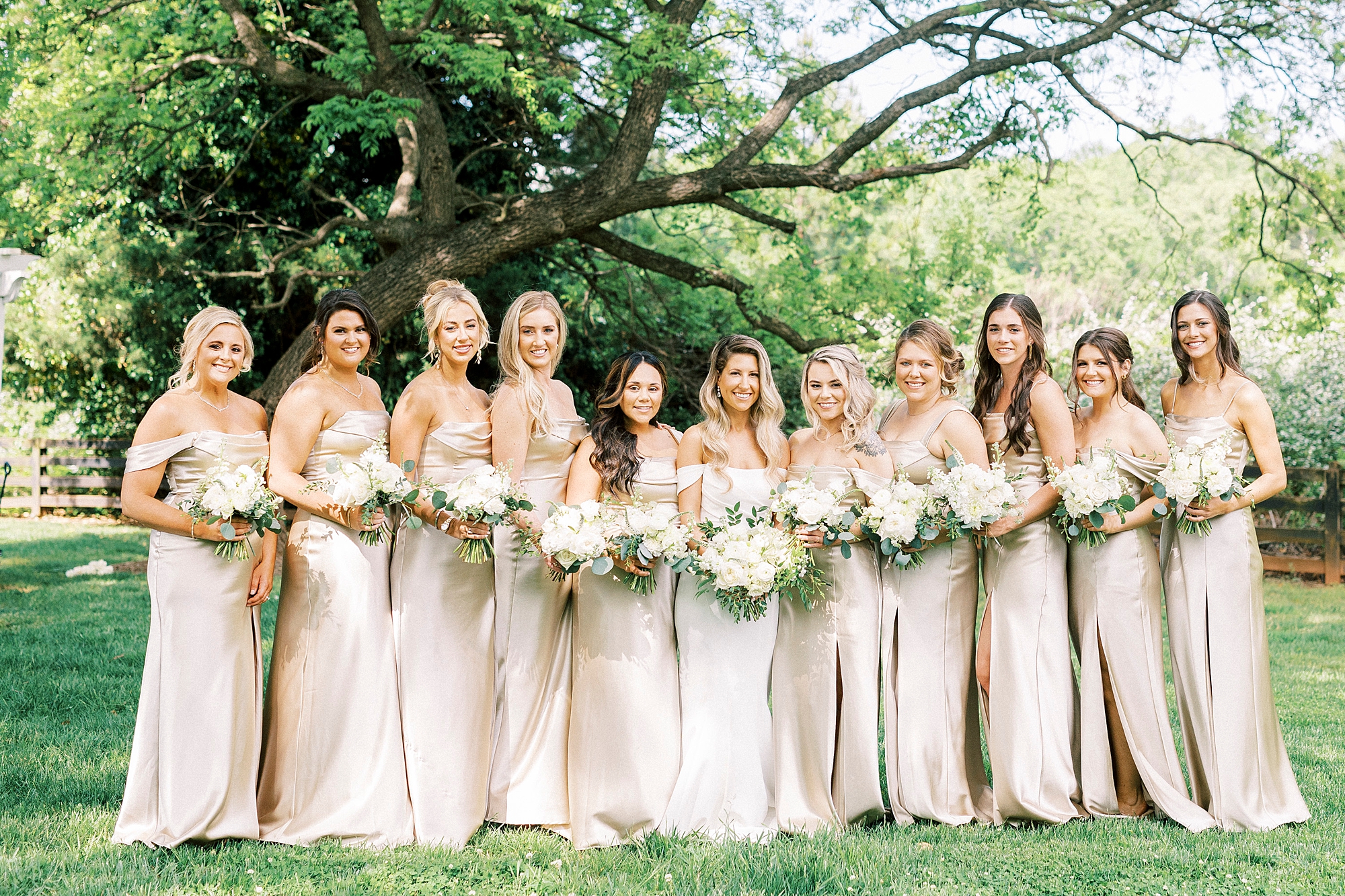 bride stands with bridesmaids in pink gowns