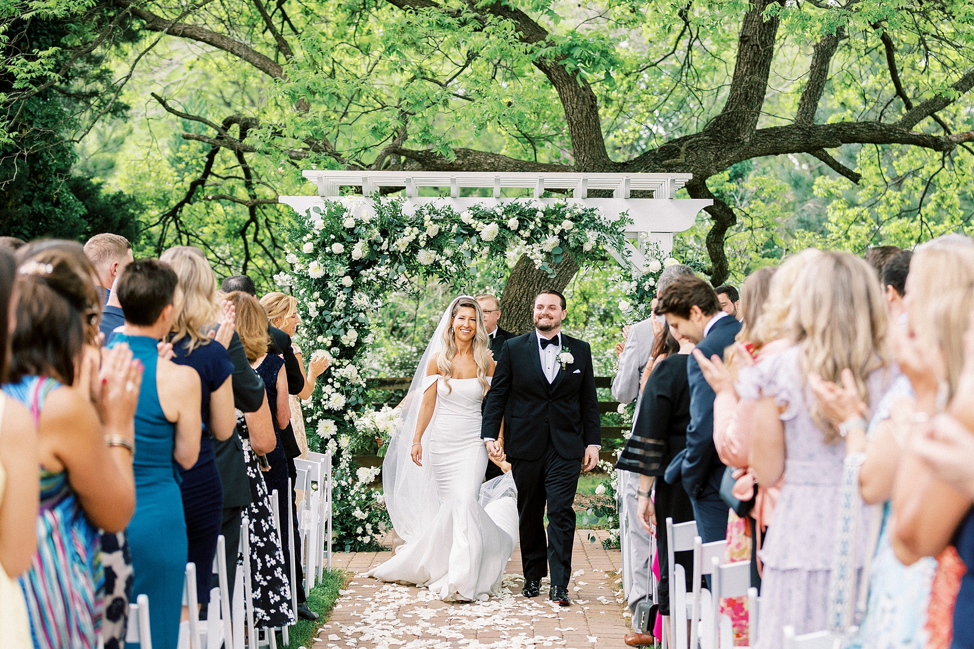 bride and groom walk down aisle away from arbor at the Venues at Langtree