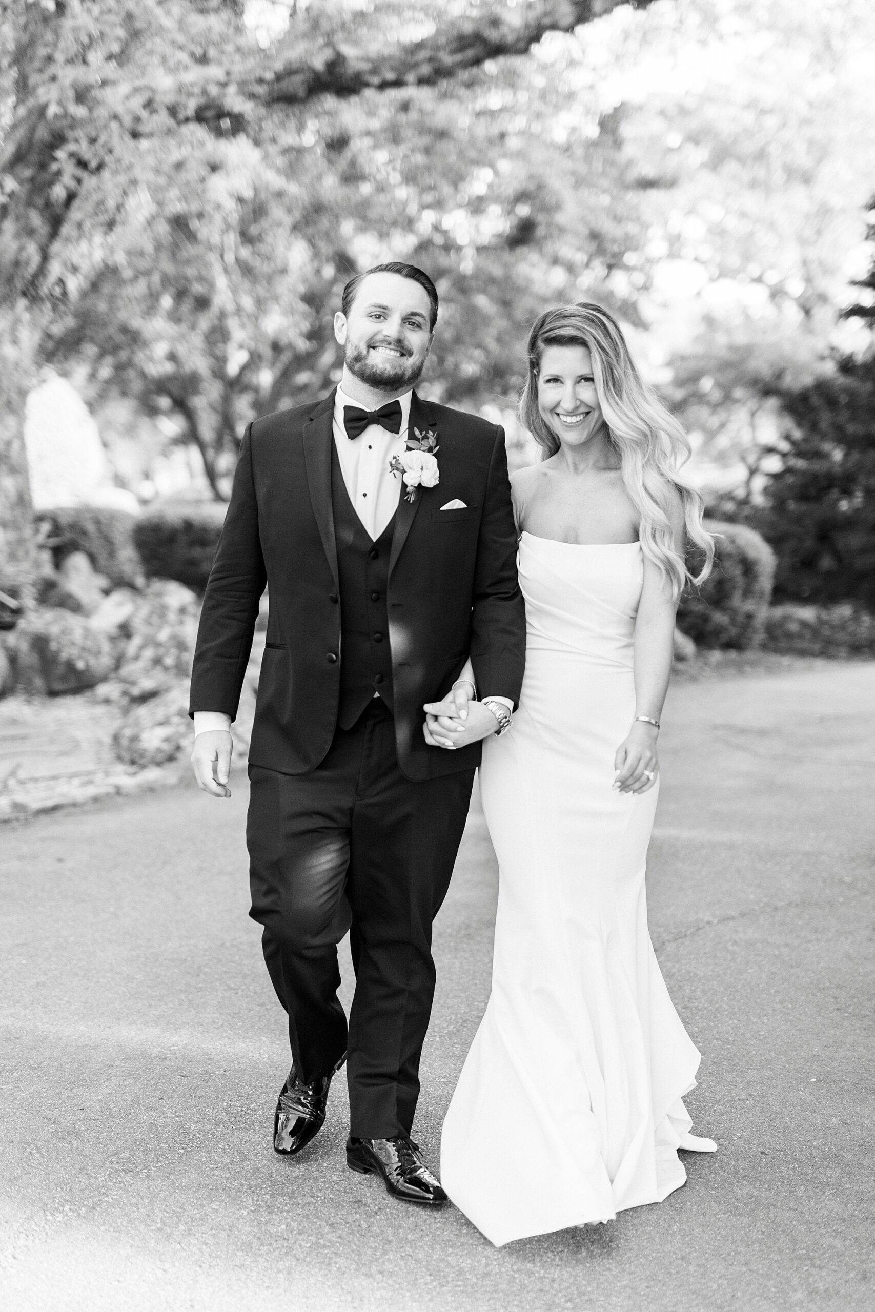 bride and groom hold hands walking on lawn together at the Venues at Langtree
