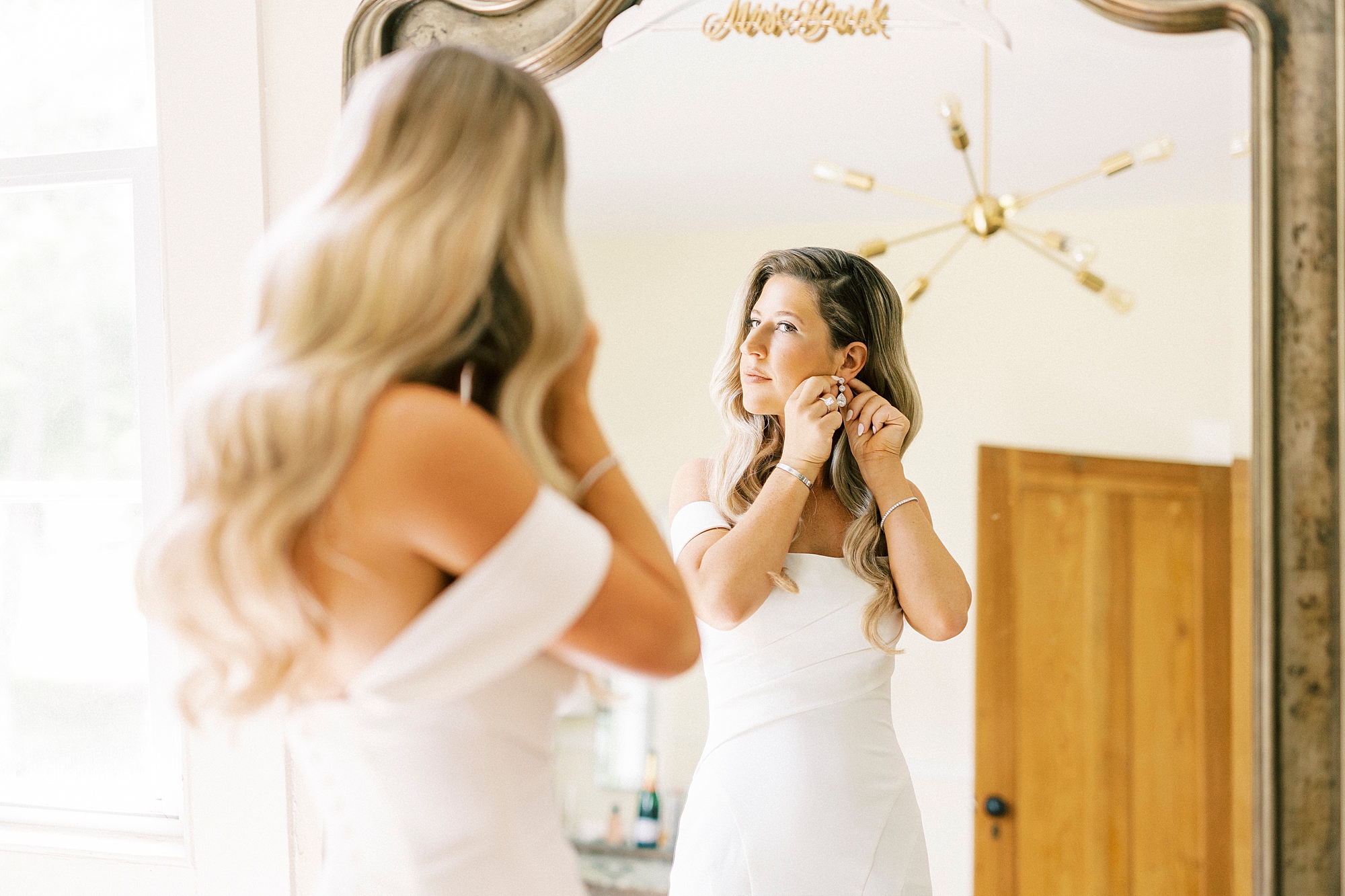 bride adjusts earrings in suite at the Venues at Langtree