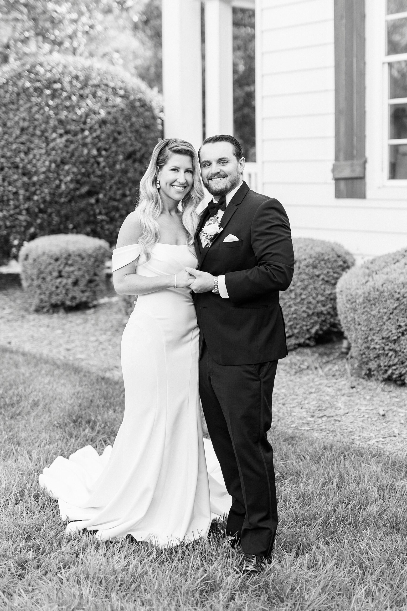 bride and groom hold hands leaning heads together after first look at the Venues at Langtree