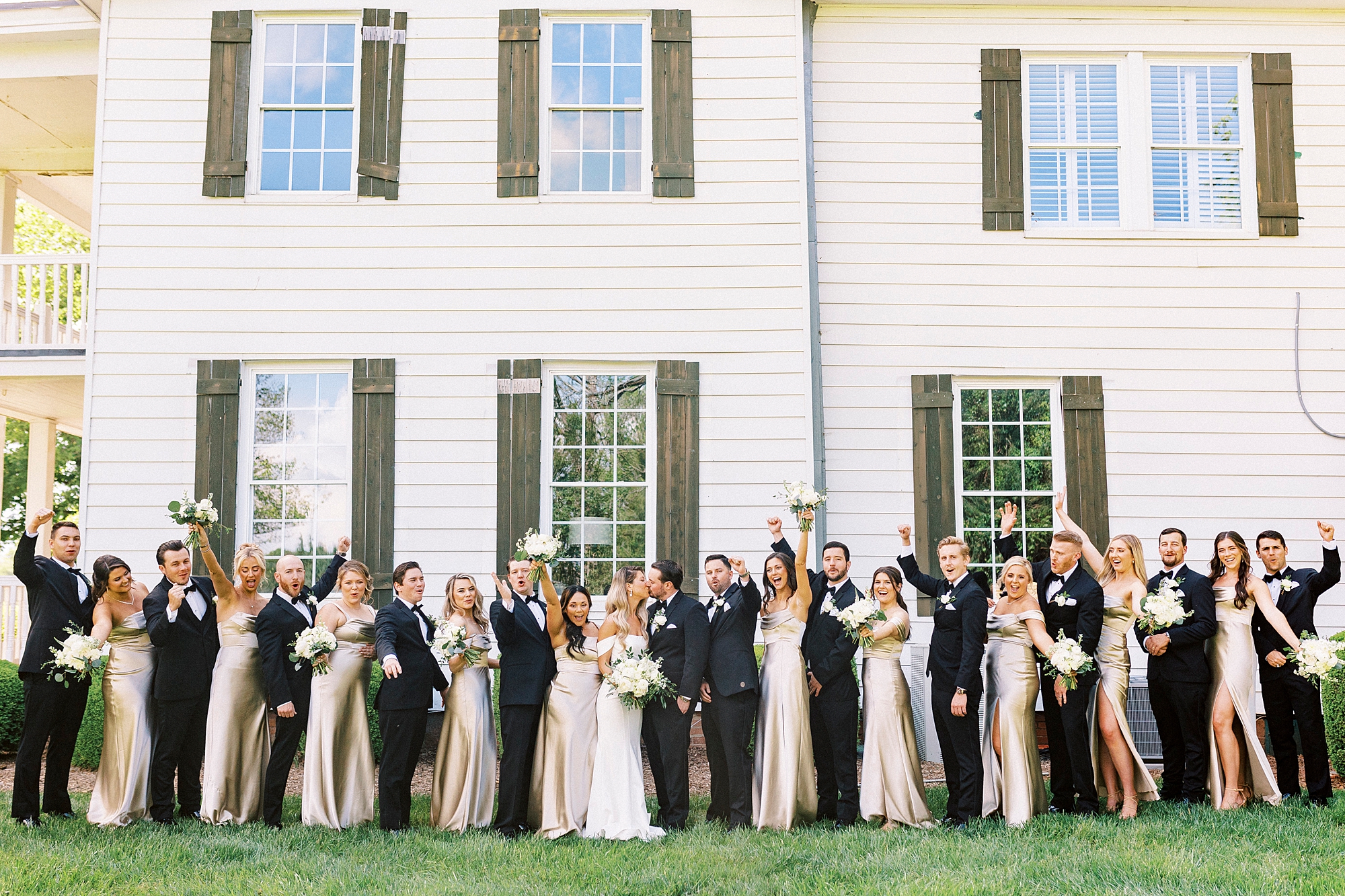 bride and groom cheer outside the Venues at Langtree with wedding party around them