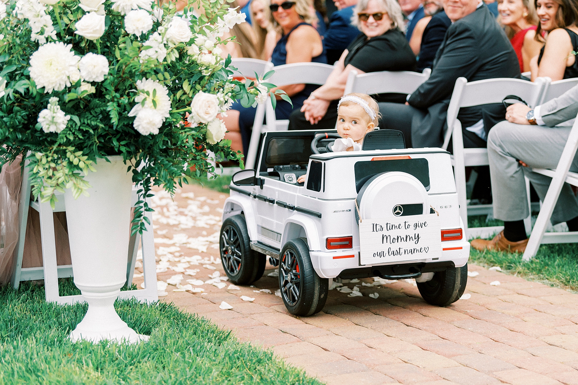 toddler rides down aisle in motorized white jeep