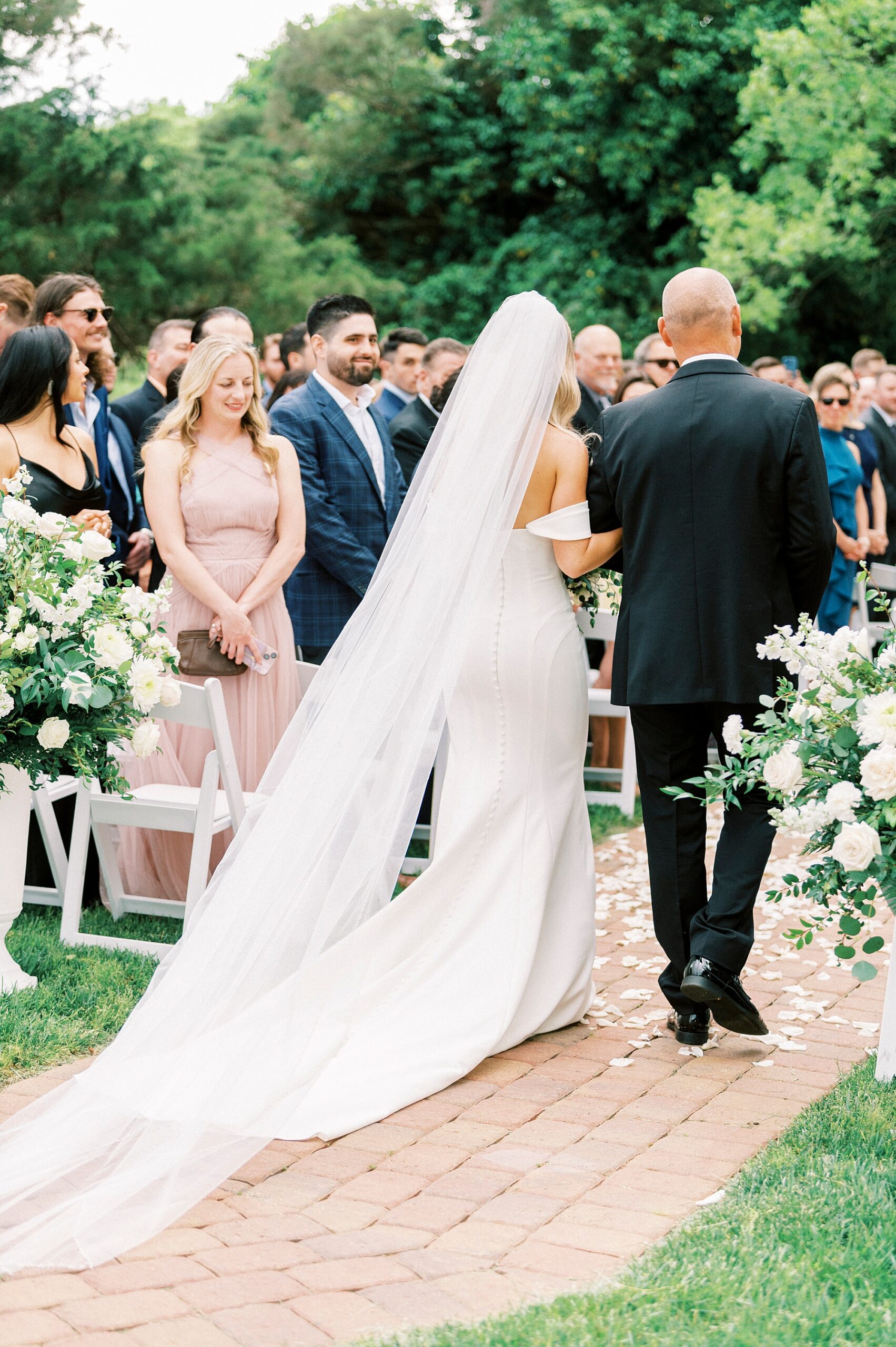 bride walks down aisle on father's arm at the Venues at Langtree