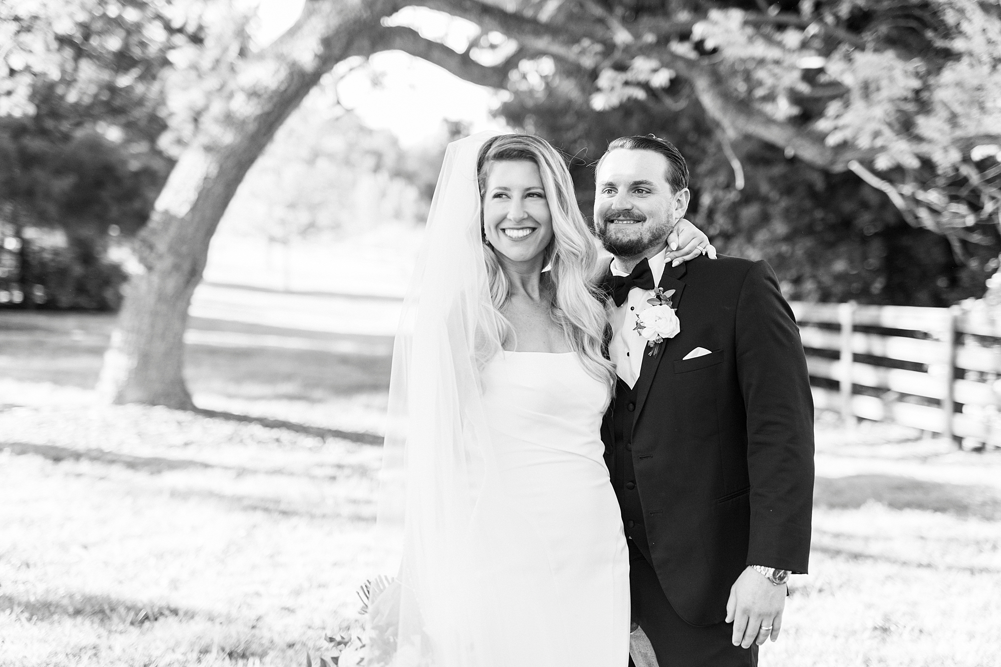 bride and groom hug smiling in pasture at the Venues at Langtree